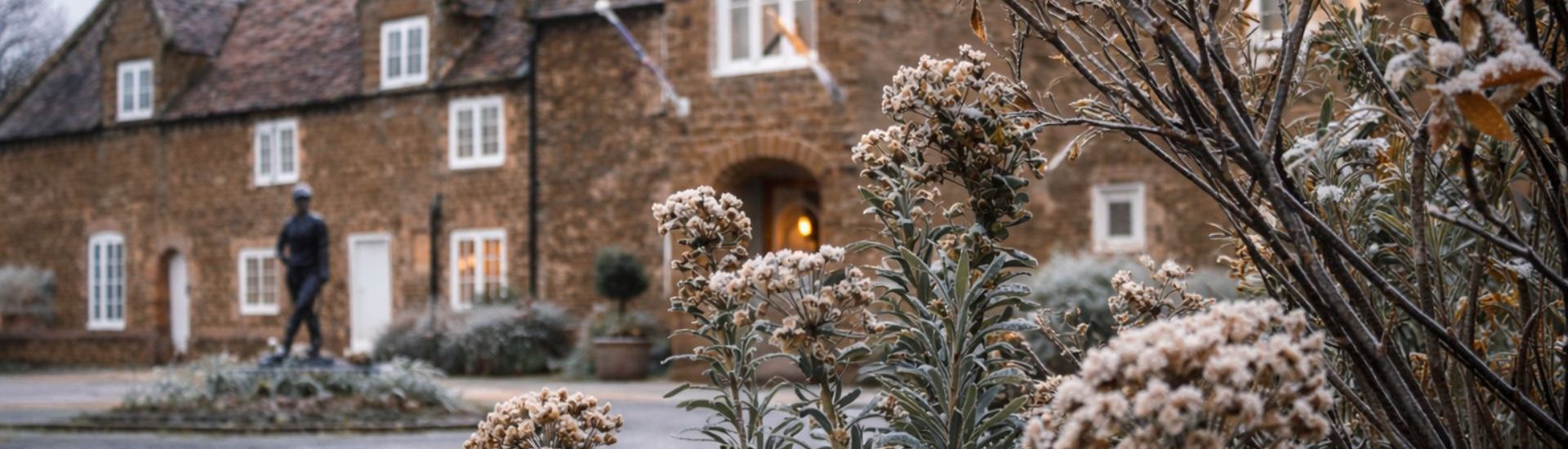 Historic hotel front with frosty plants and winter foliage