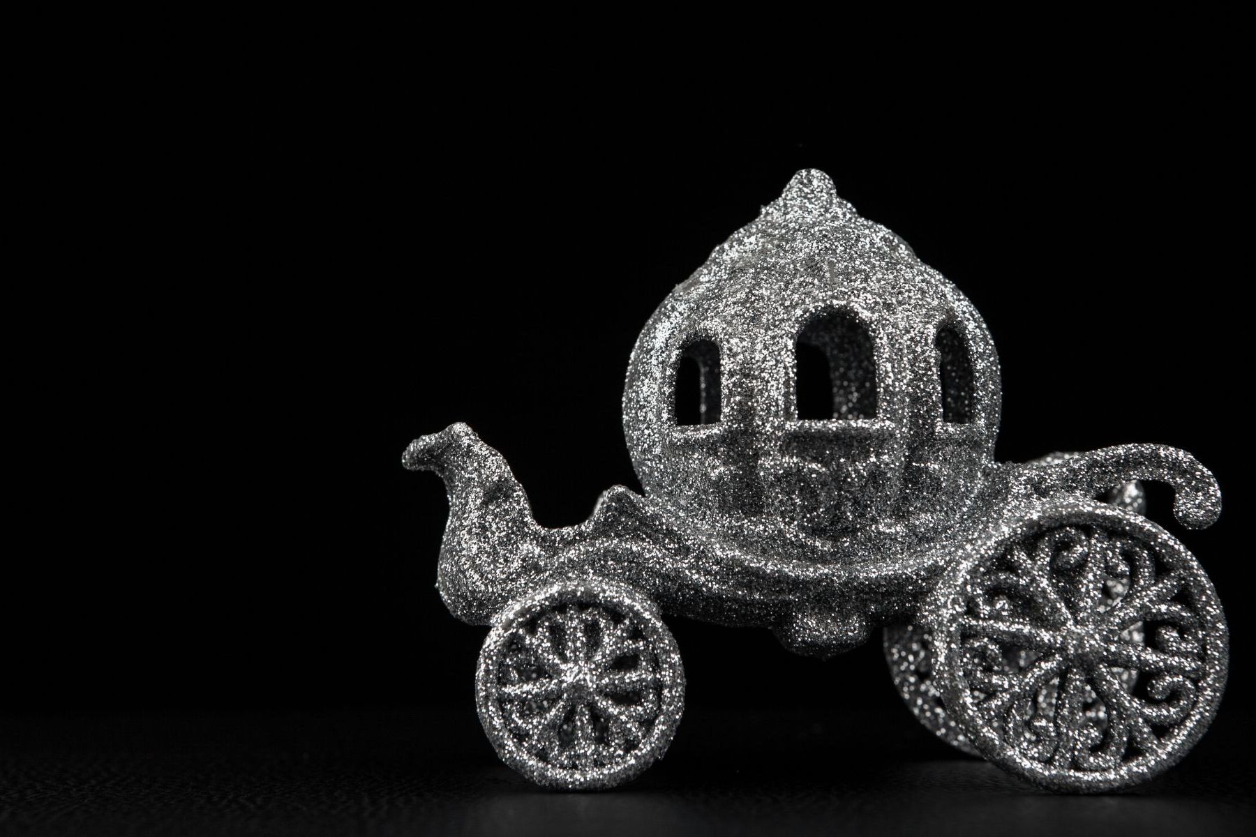 Silver glitter Cinderella-style pumpkin coach ornament on a black background