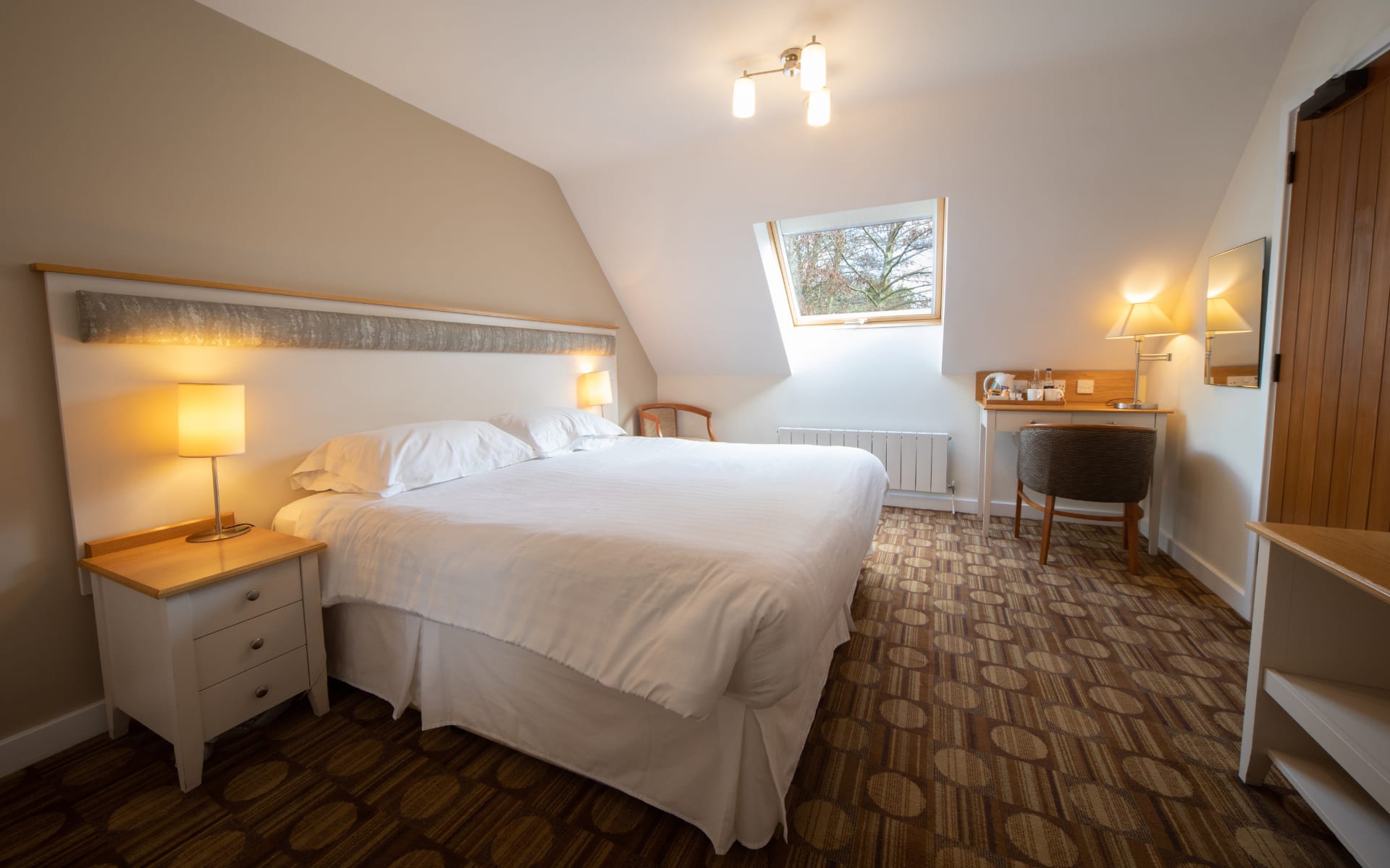 Hotel bedroom with velux roof window and double beds.