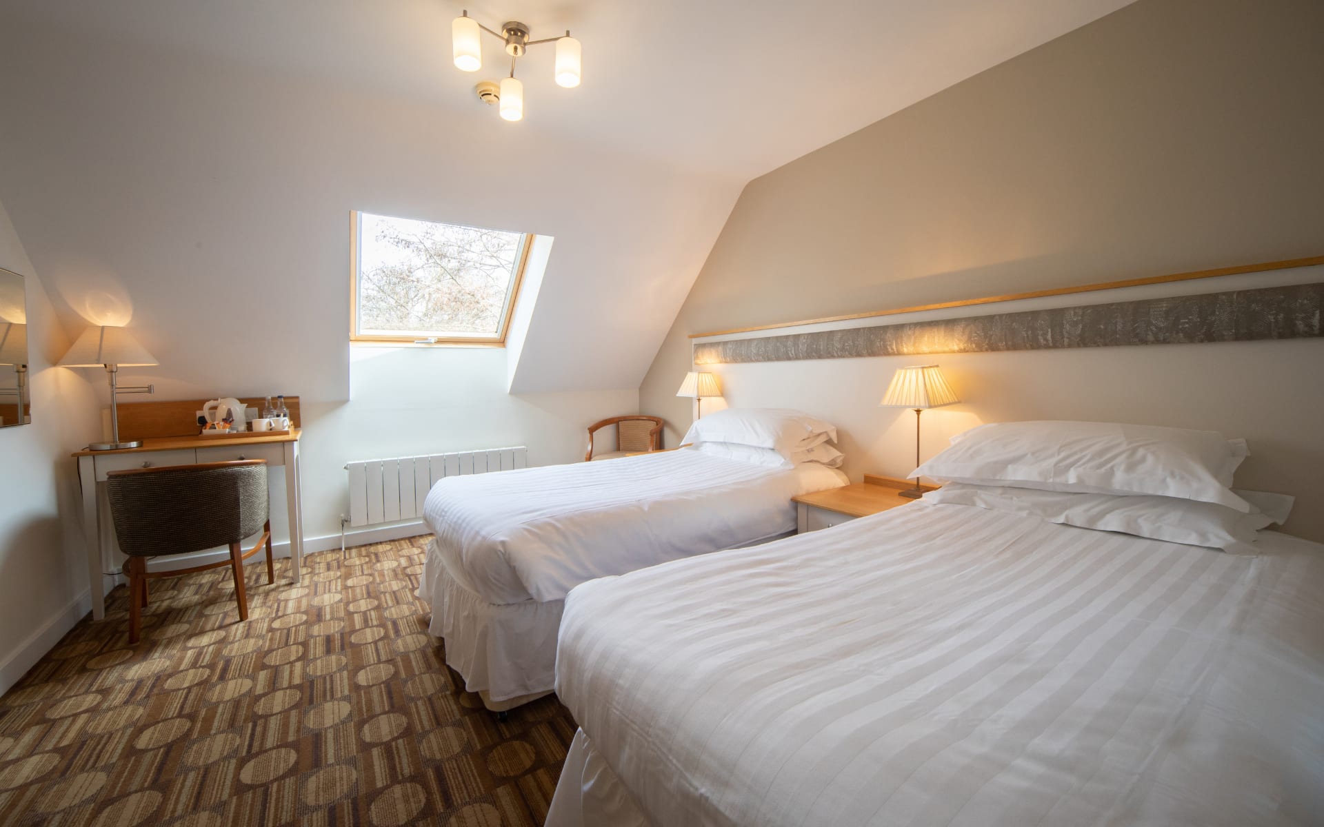 Hotel bedroom with velux roof window and twin beds.
