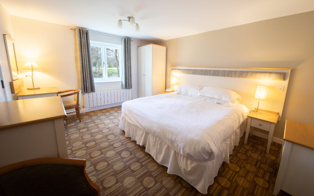 Double bedroom with light coloured furnishings and a neutral coloured walls.