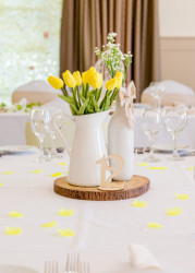 Close up of wedding table decorated with accents of yellow and tulips