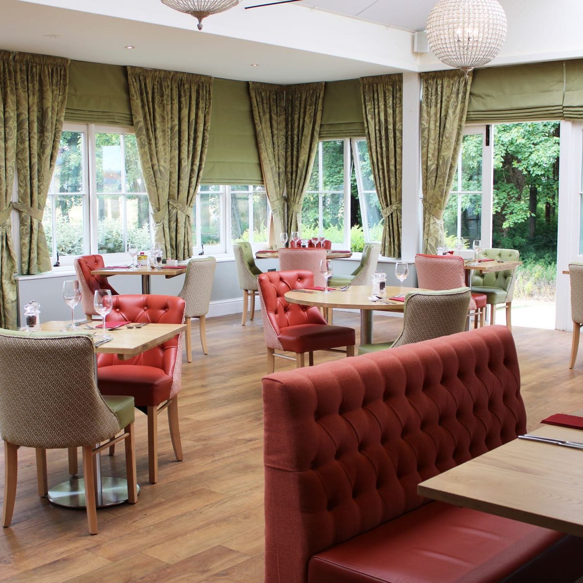 Conservatory restaurant with fresh green and orange/pink furnishings.