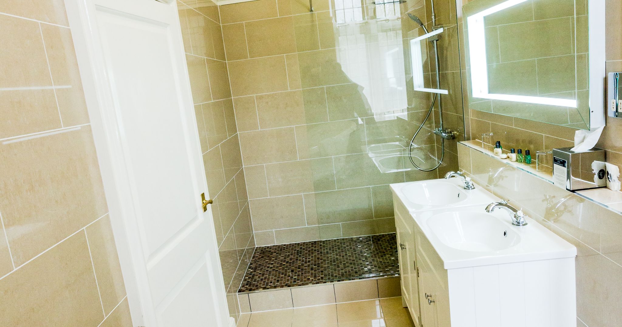 Modern bathroom with bathtub, double sink, and walk-in shower