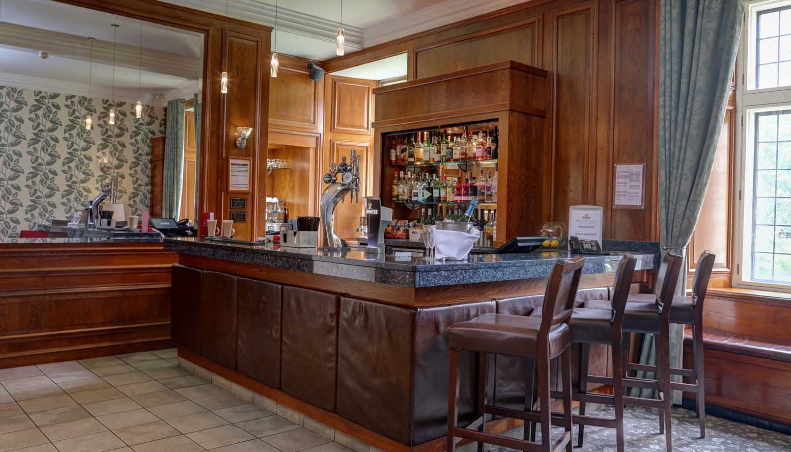 Interior view of a modern bar with wooden paneling and high chairs.