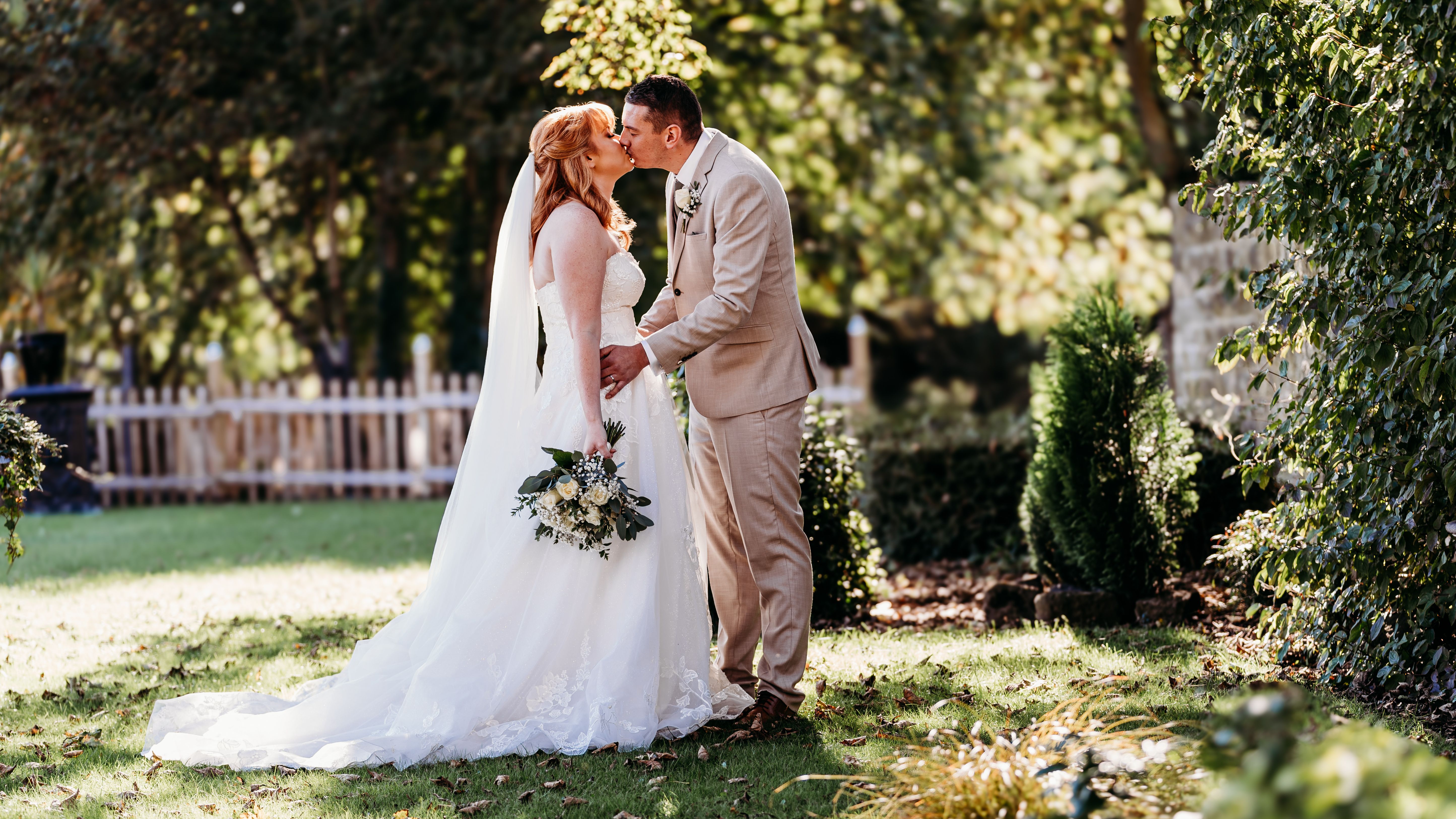Bride and groom kissing outdoors during their wedding ceremony