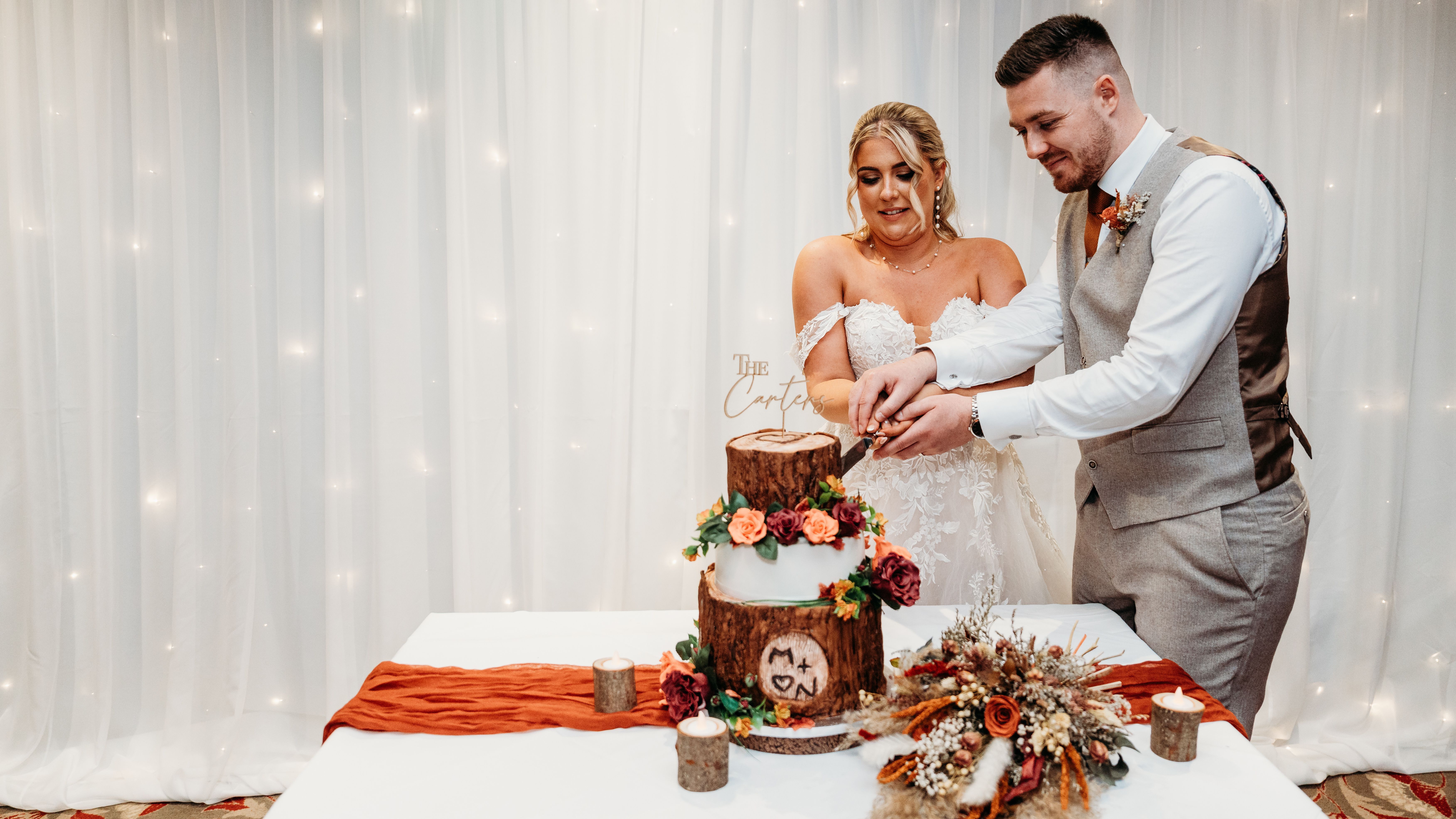 Bride and groom cutting a rustic wedding cake together
