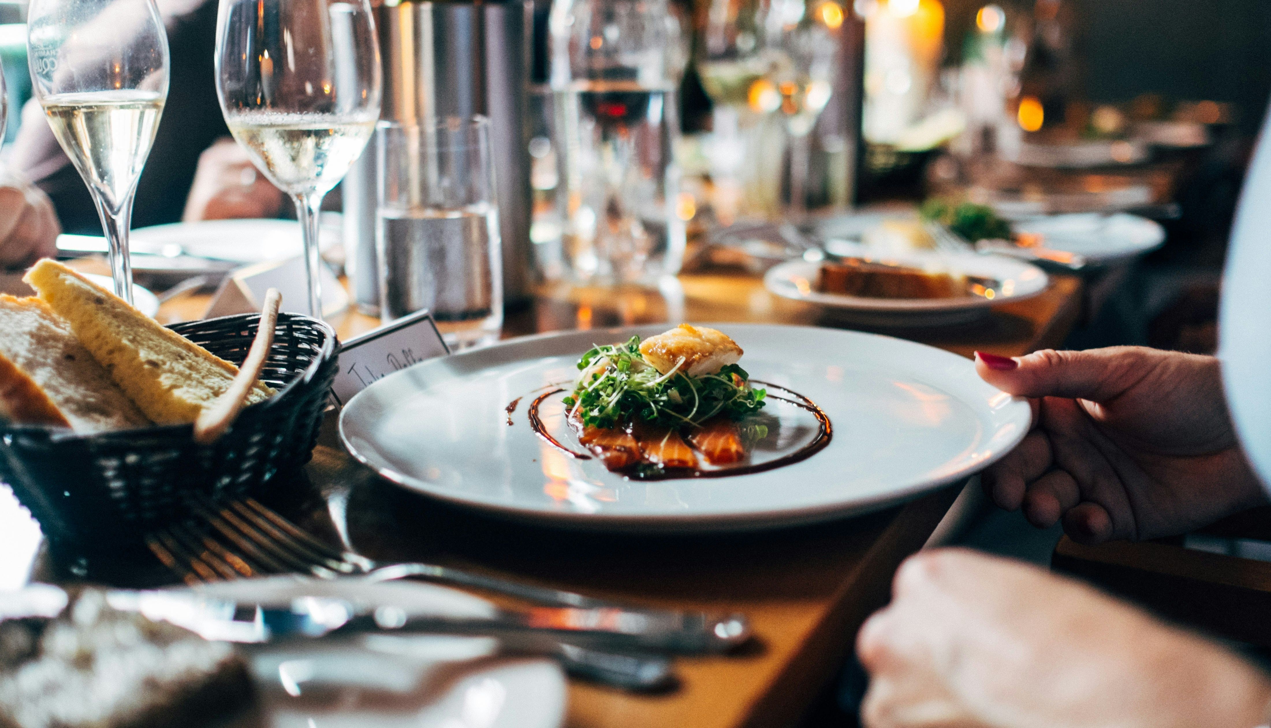 Gourmet dish served at a restaurant with wine glasses and bread on the table