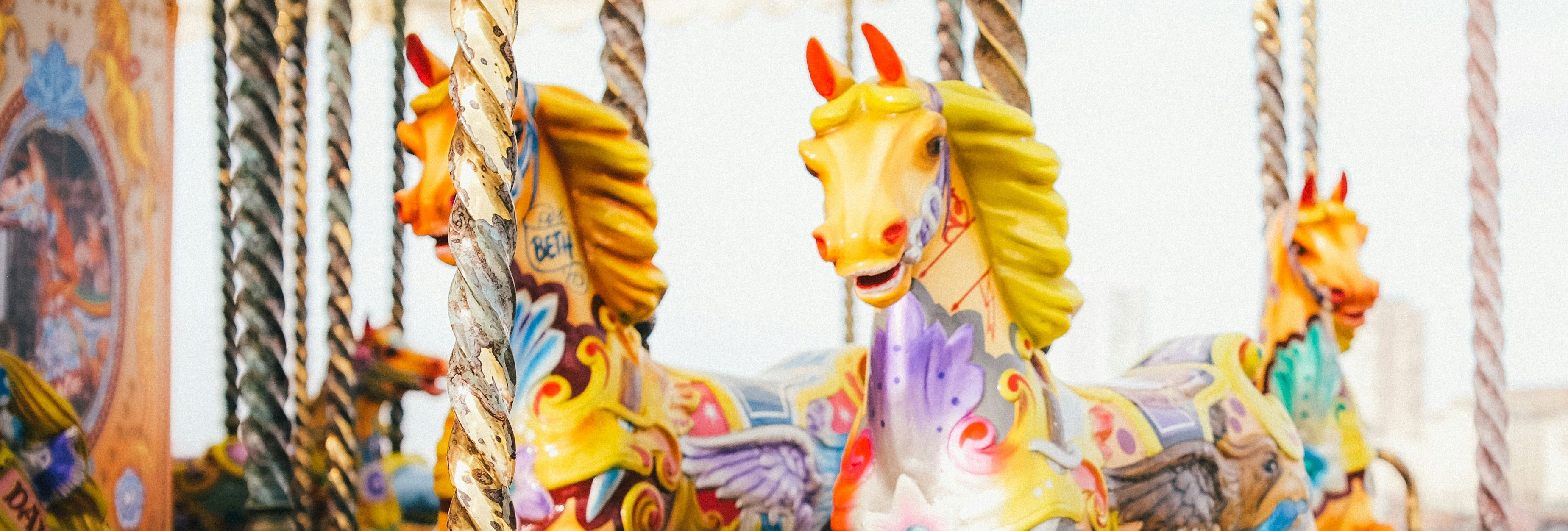 Close-up of colorful carousel horses on a traditional merry-go-round.