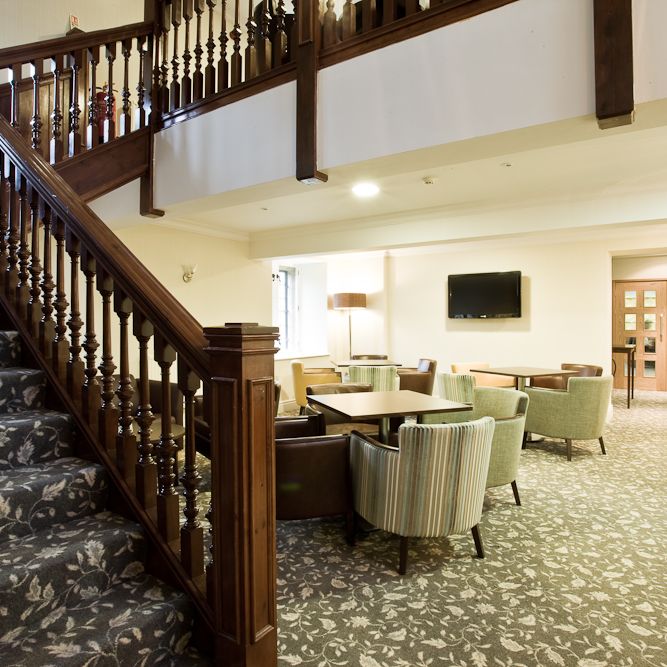 Elegant lobby area with wooden staircase and lounge seating