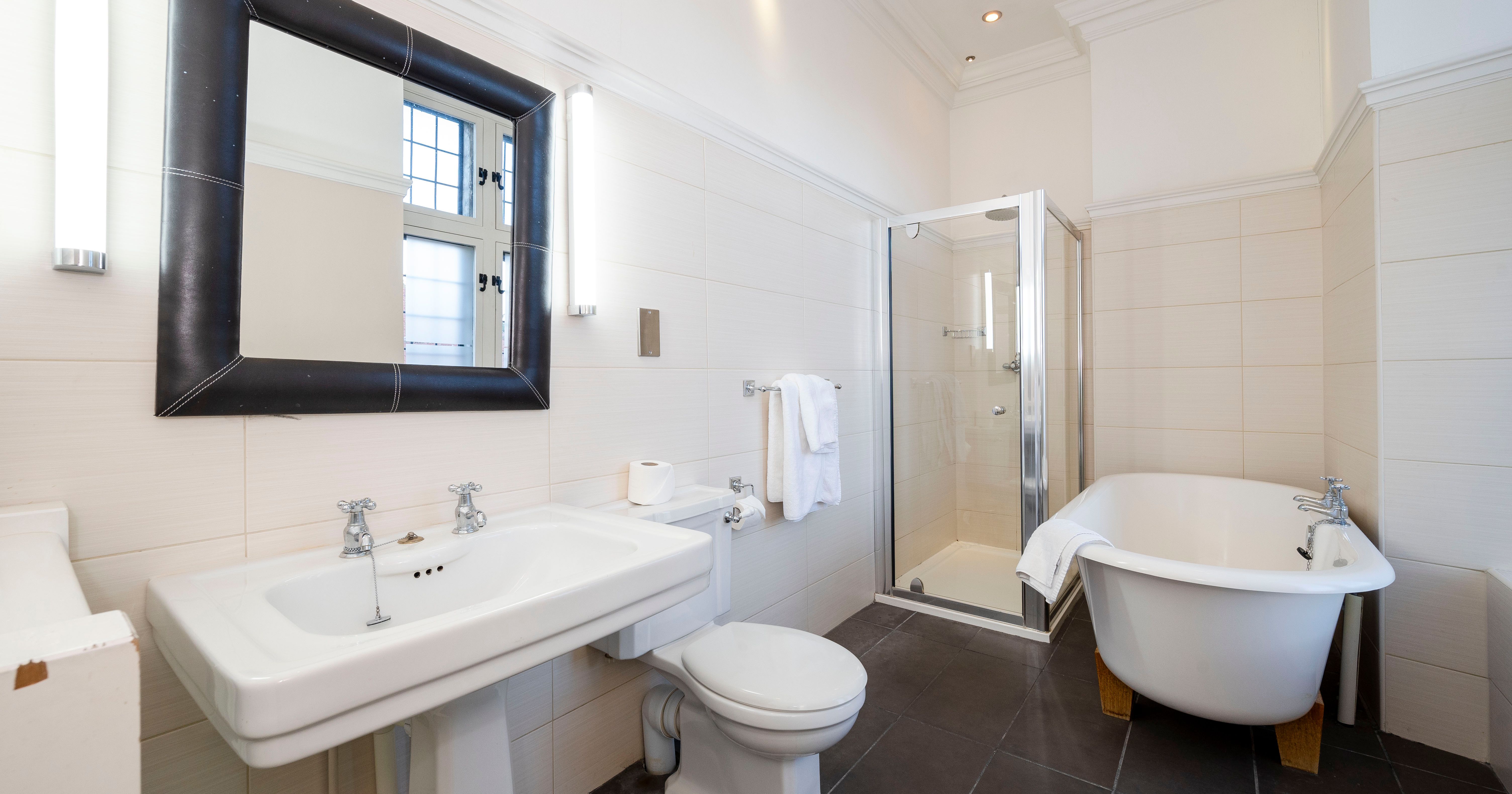 Modern bathroom with a sink, toilet, glass shower, and freestanding bathtub