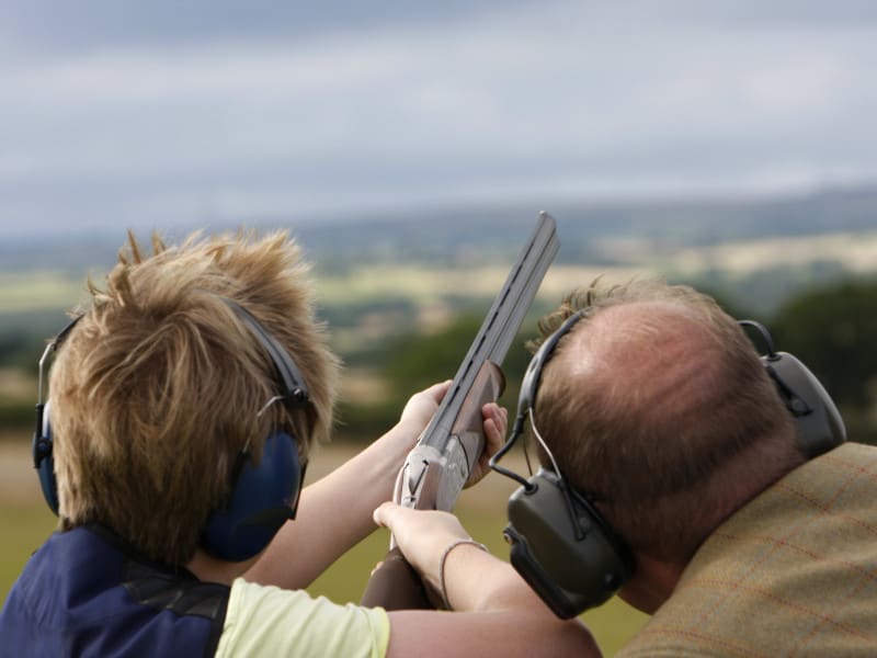 Two people clay pigeon shooting.