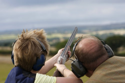 Two people clay pigeon shooting.