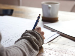 Person writing in a note book