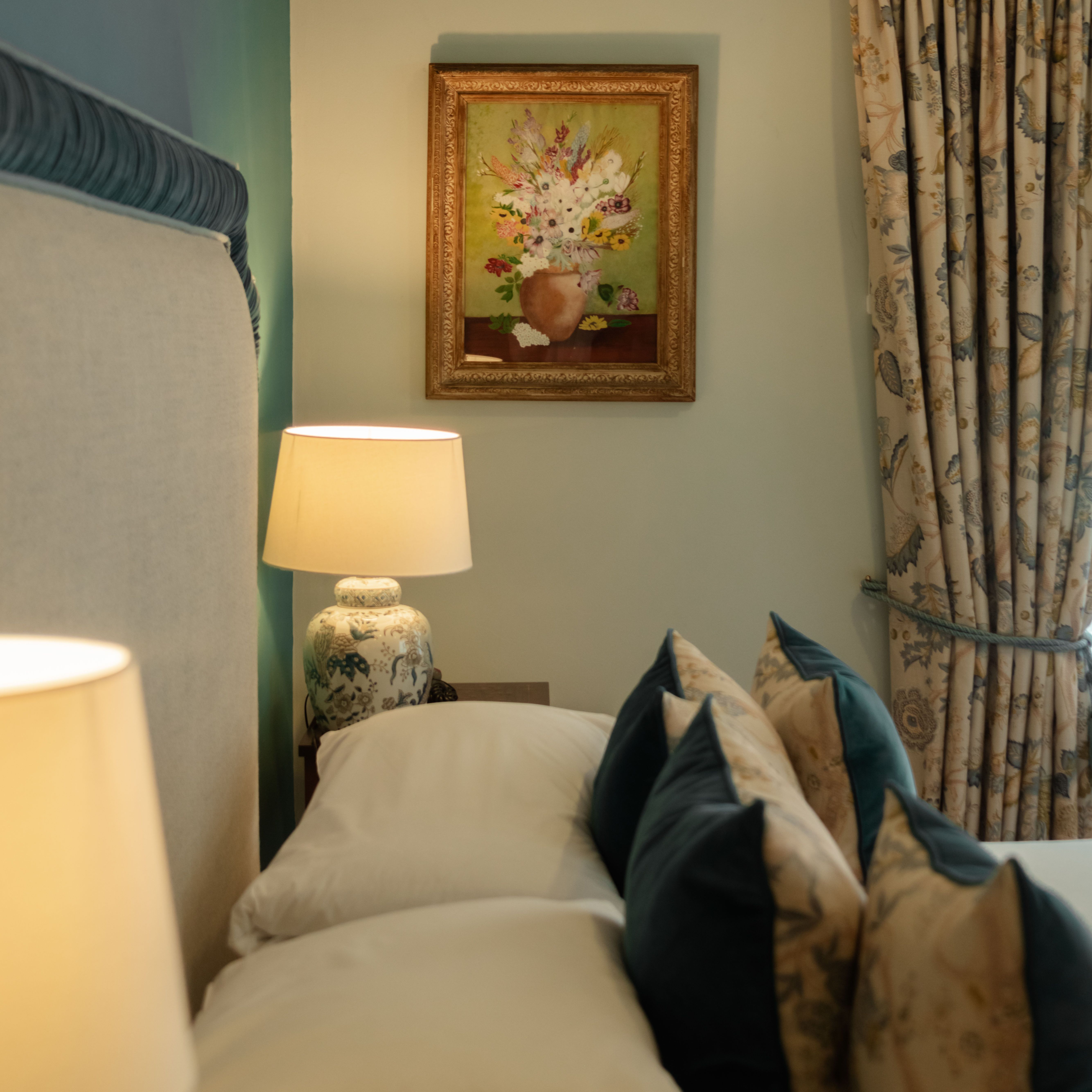 Cozy bedroom corner with floral-themed decor, soft pillows, and warm lighting