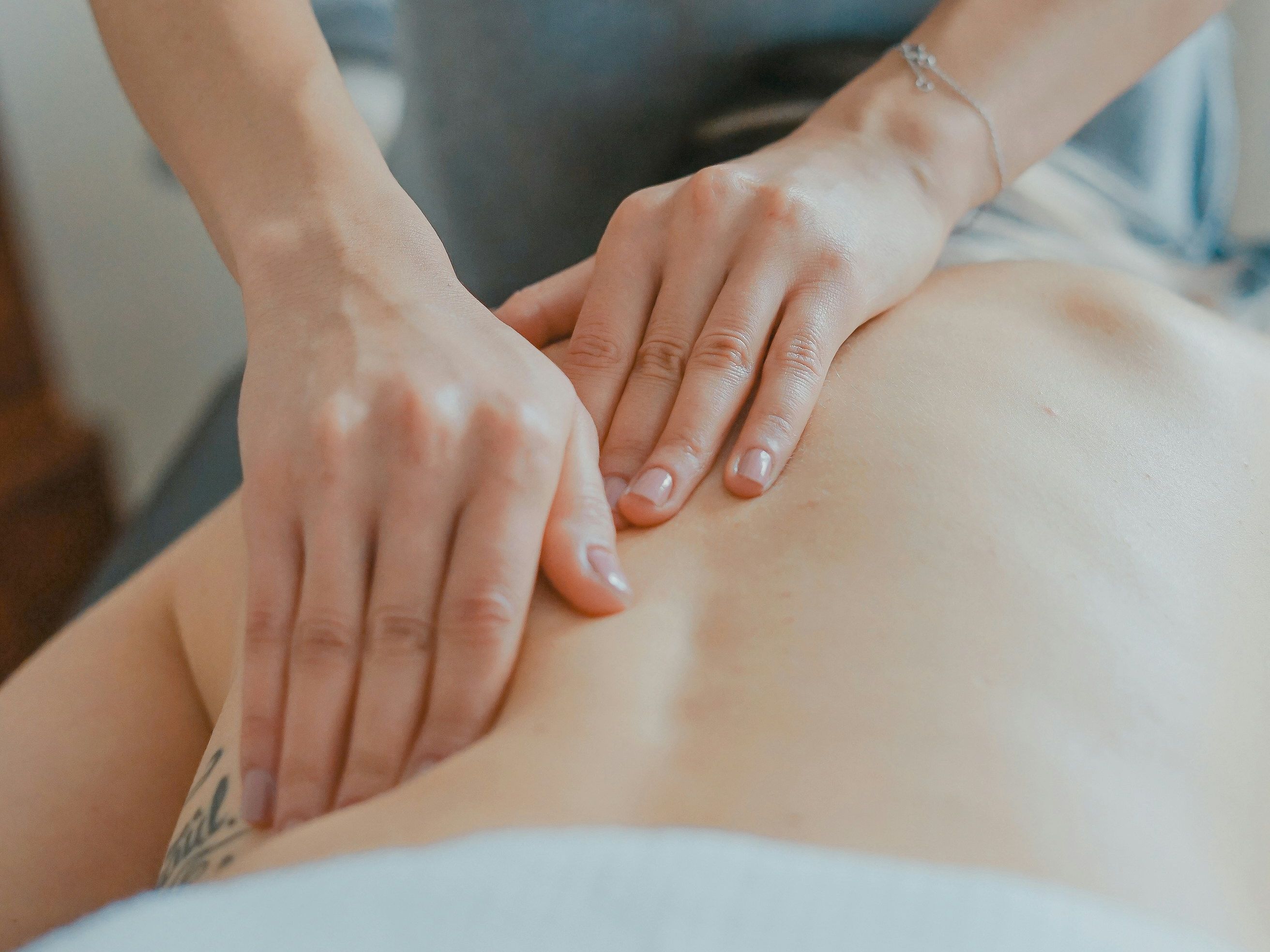 Person receiving a back massage from a professional masseuse.