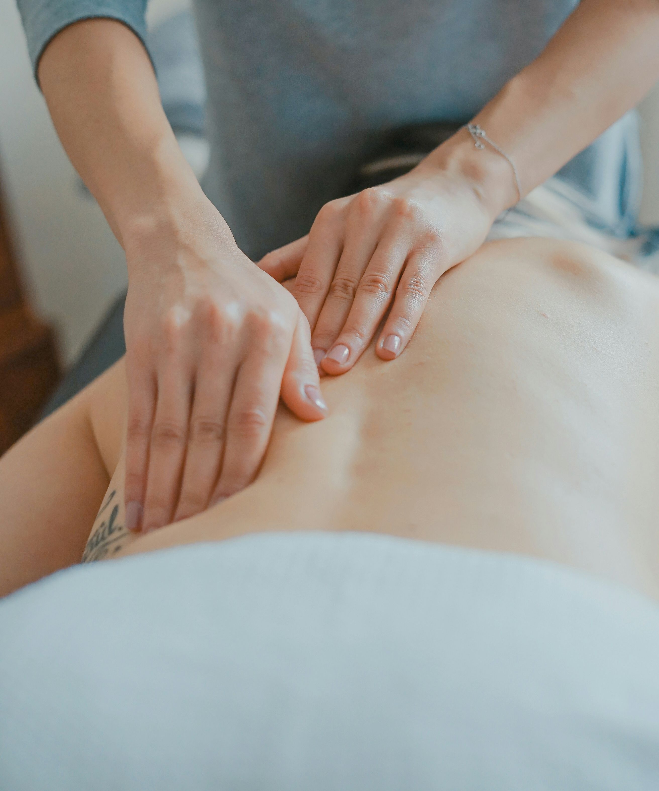 Person receiving a back massage from a professional masseuse.