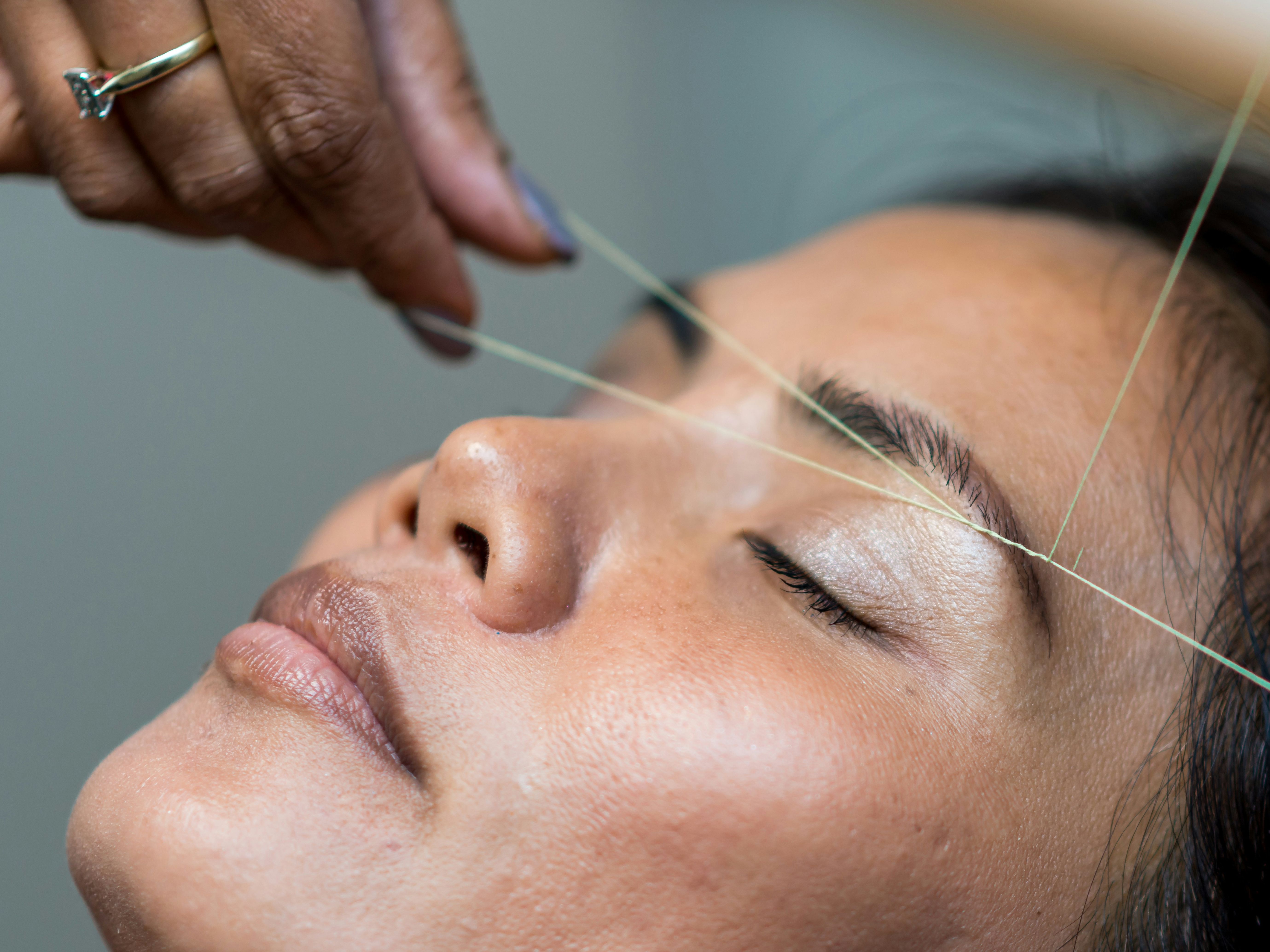 Close-up of a person having their eyebrows threaded