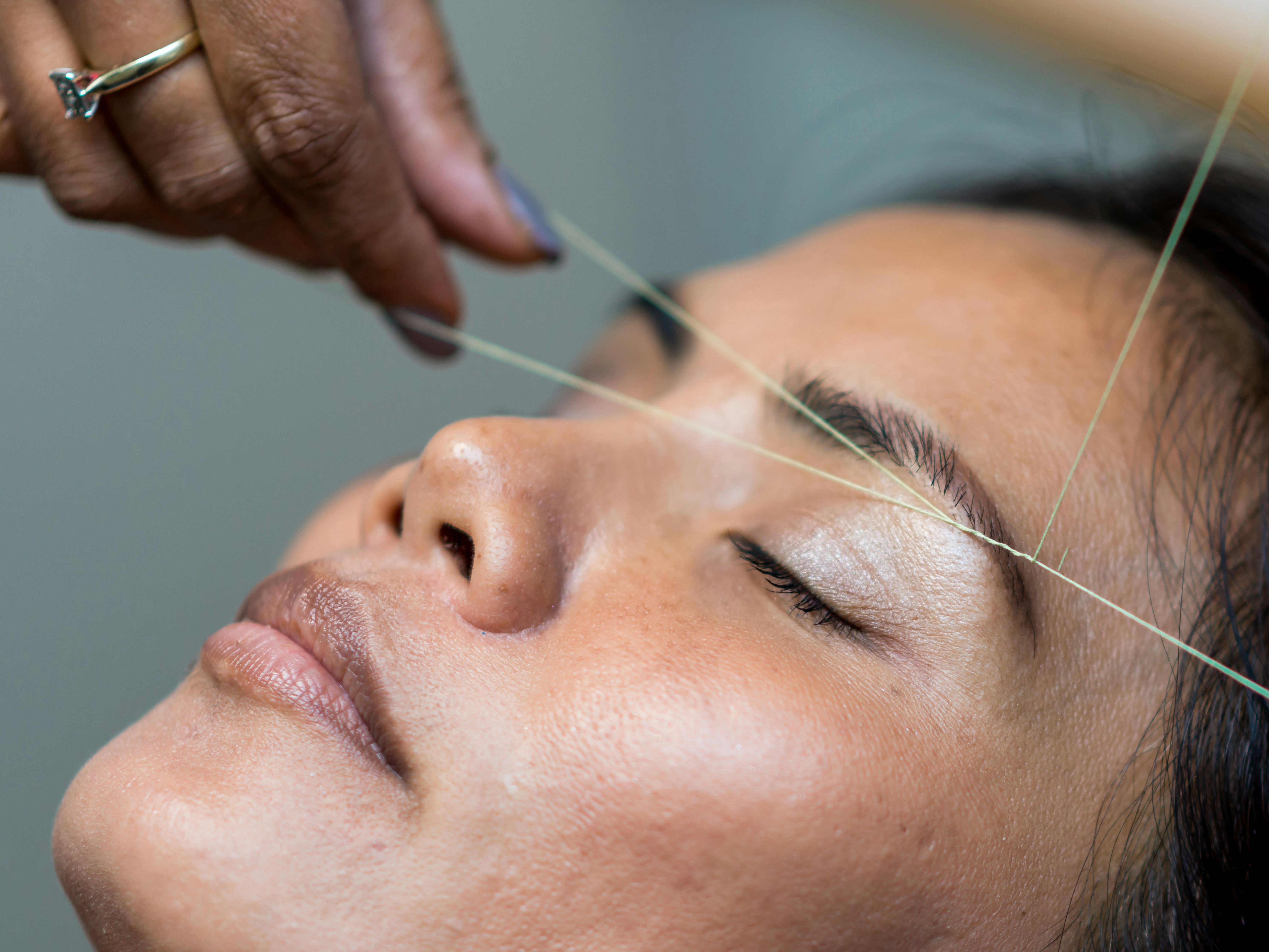 Close-up of a person having their eyebrows threaded