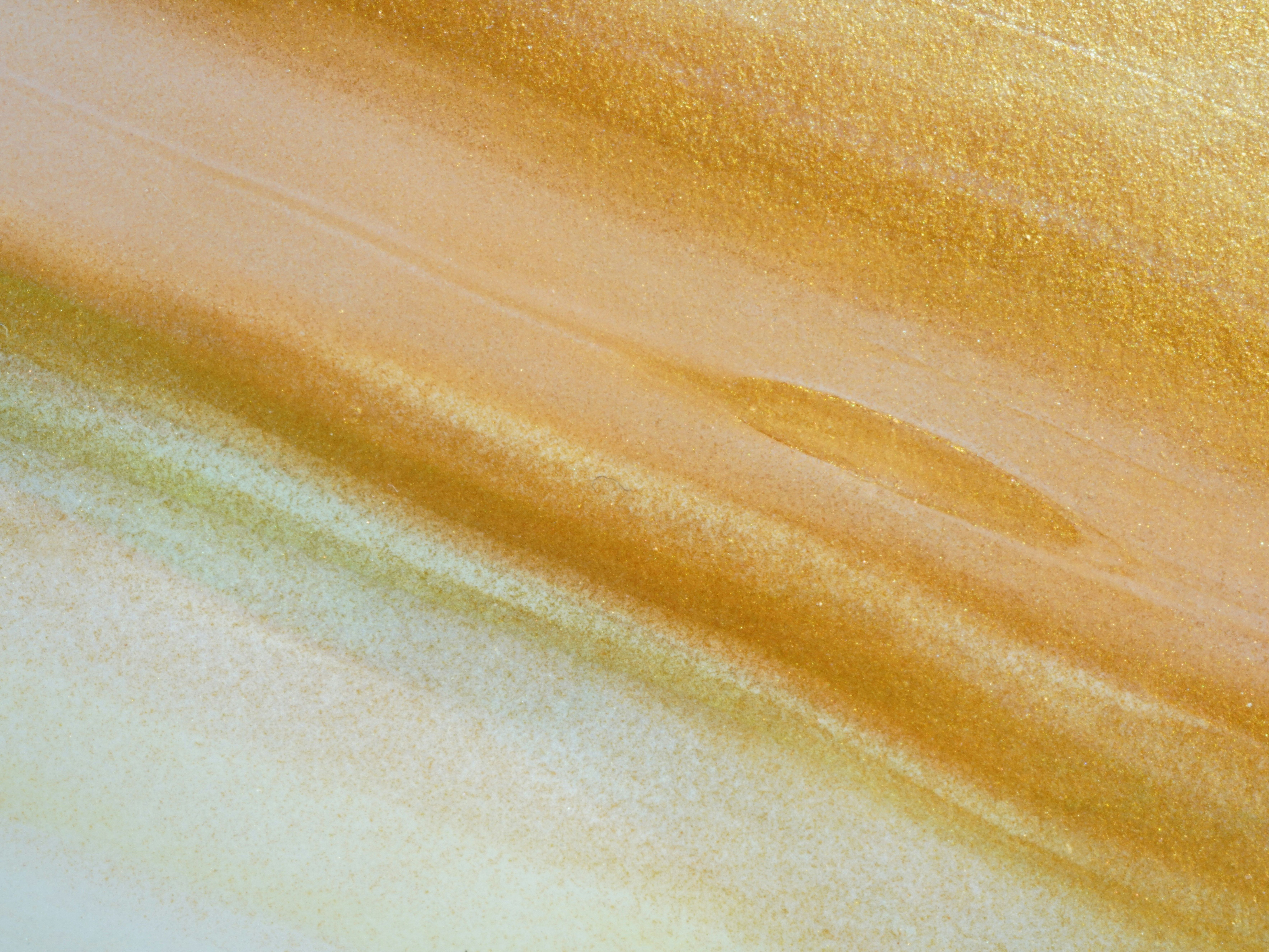 Close-up of gold and ochre abstract texture with shimmering and wavy lines