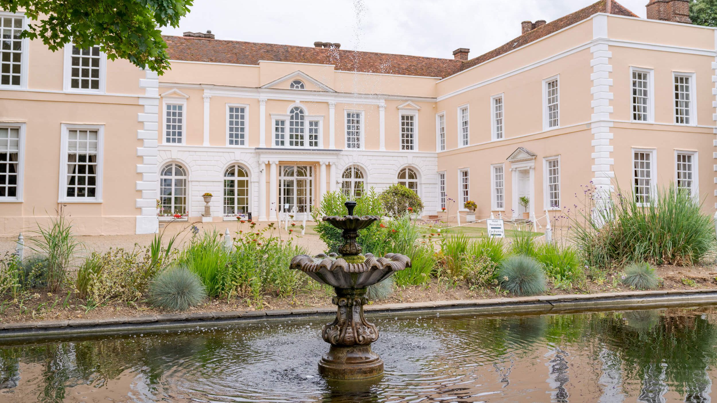 Large elegant manor house with a fountain in the front garden