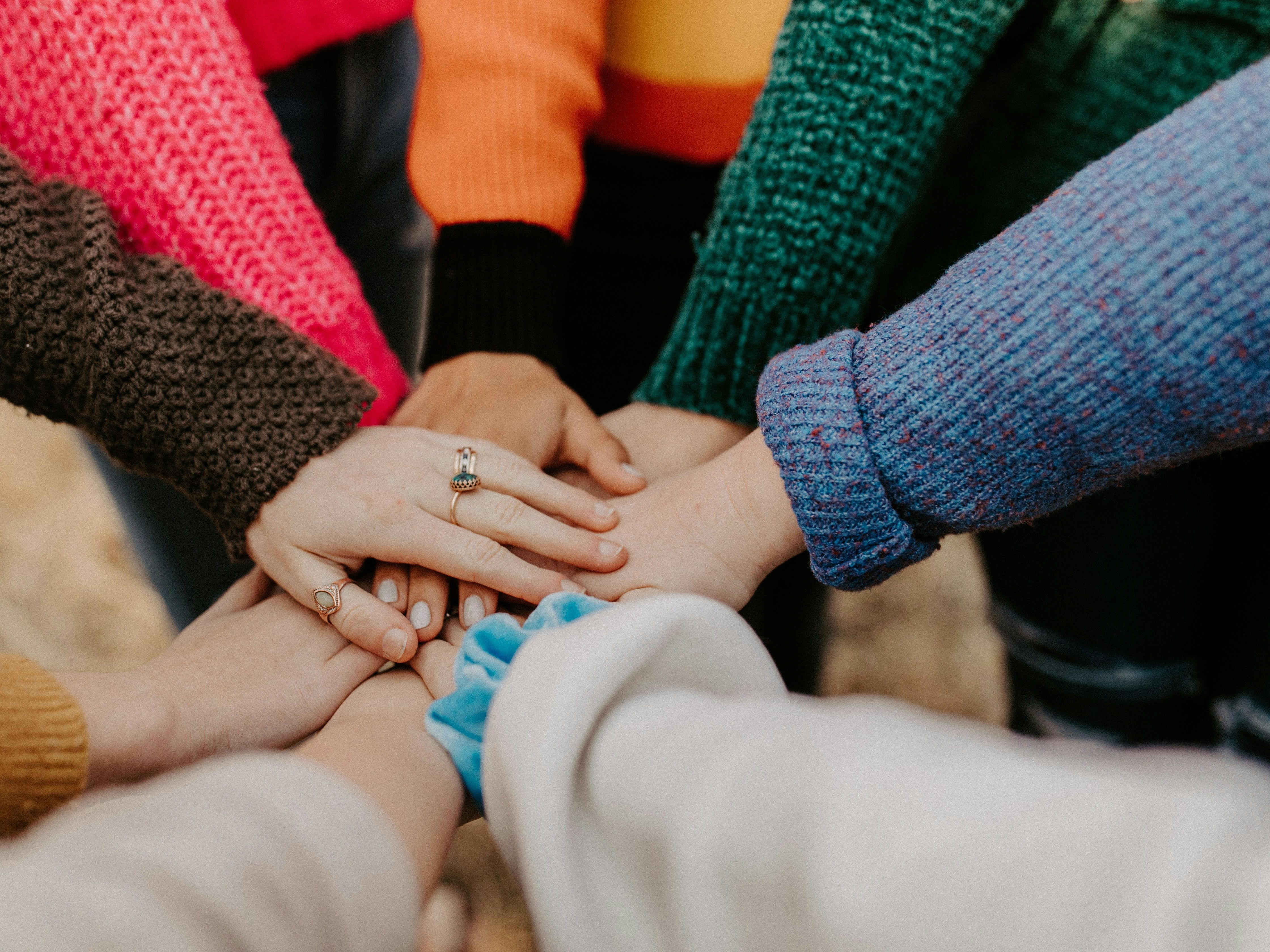 Group of people putting their hands together in a show of unity