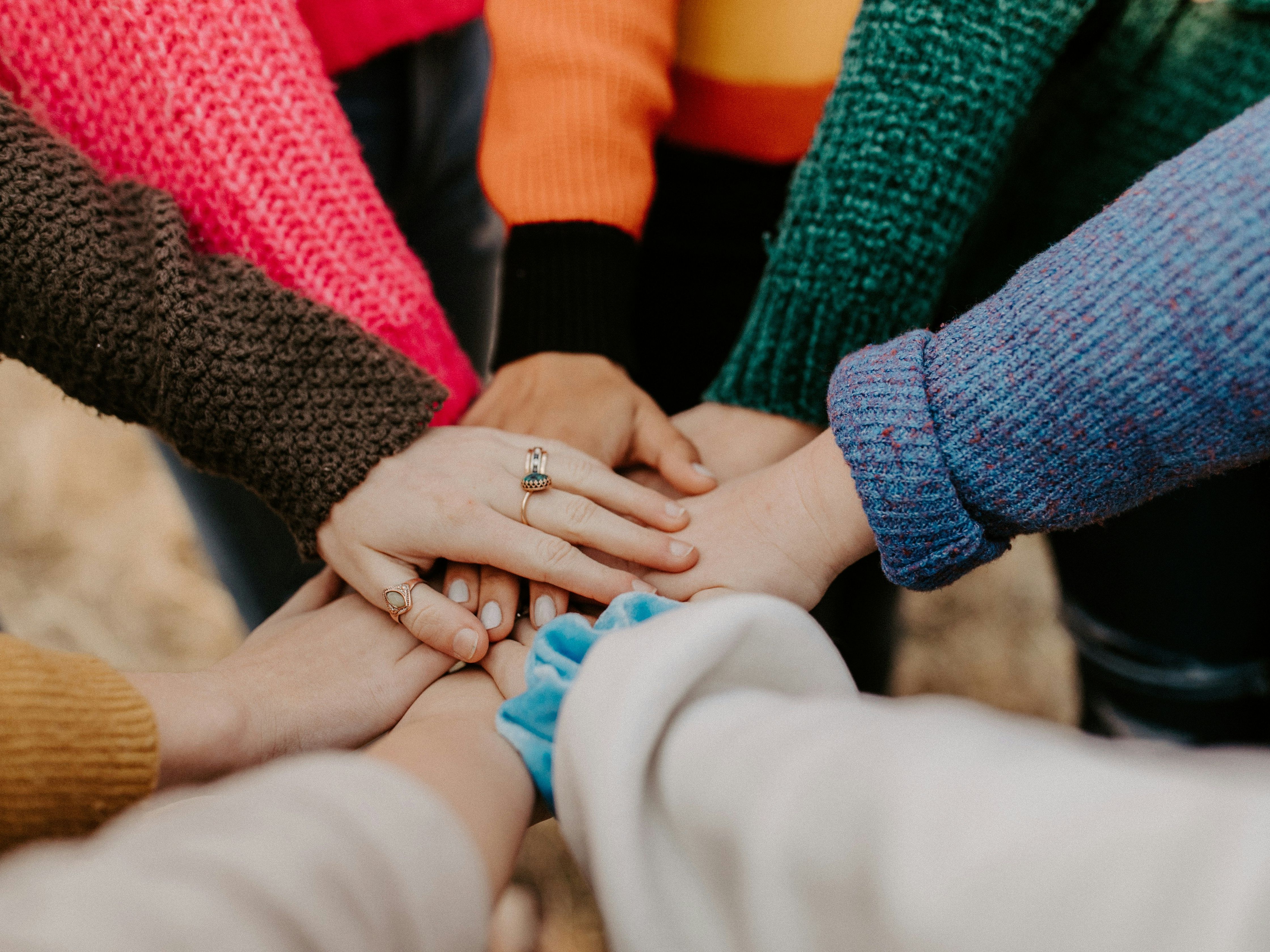Group of people putting their hands together in a show of unity
