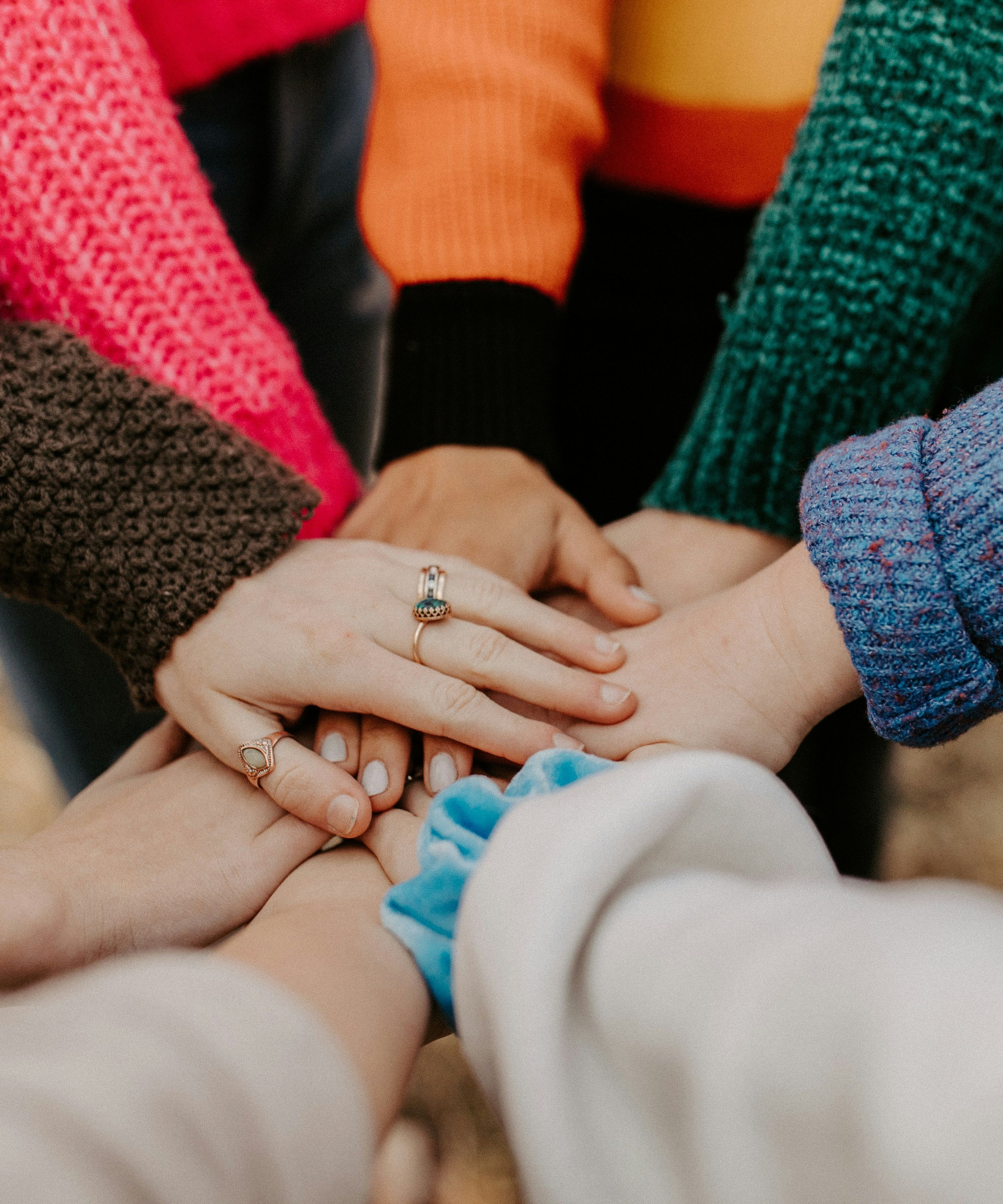 Group of people putting their hands together in a show of unity