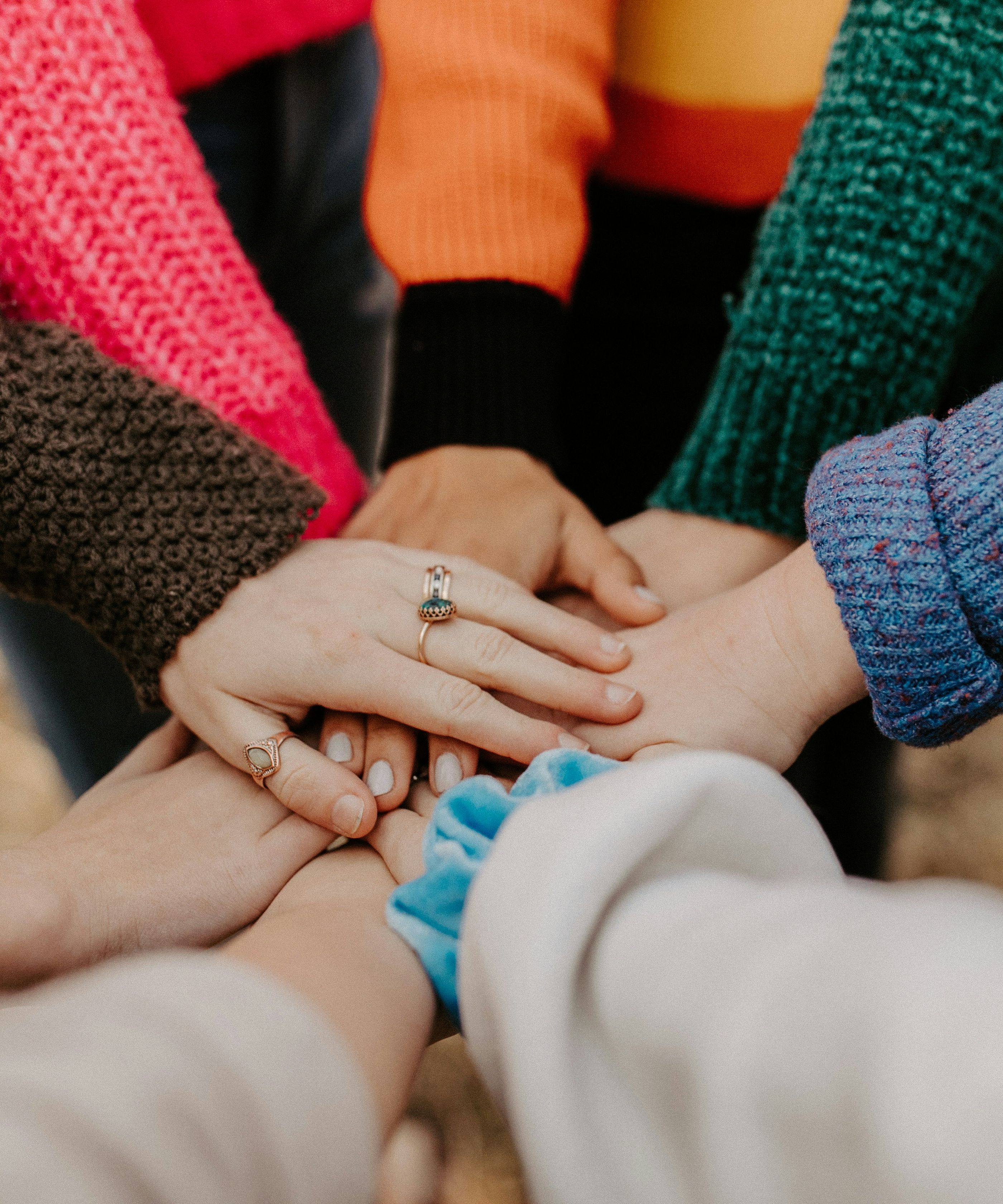 Group of people putting their hands together in a show of unity