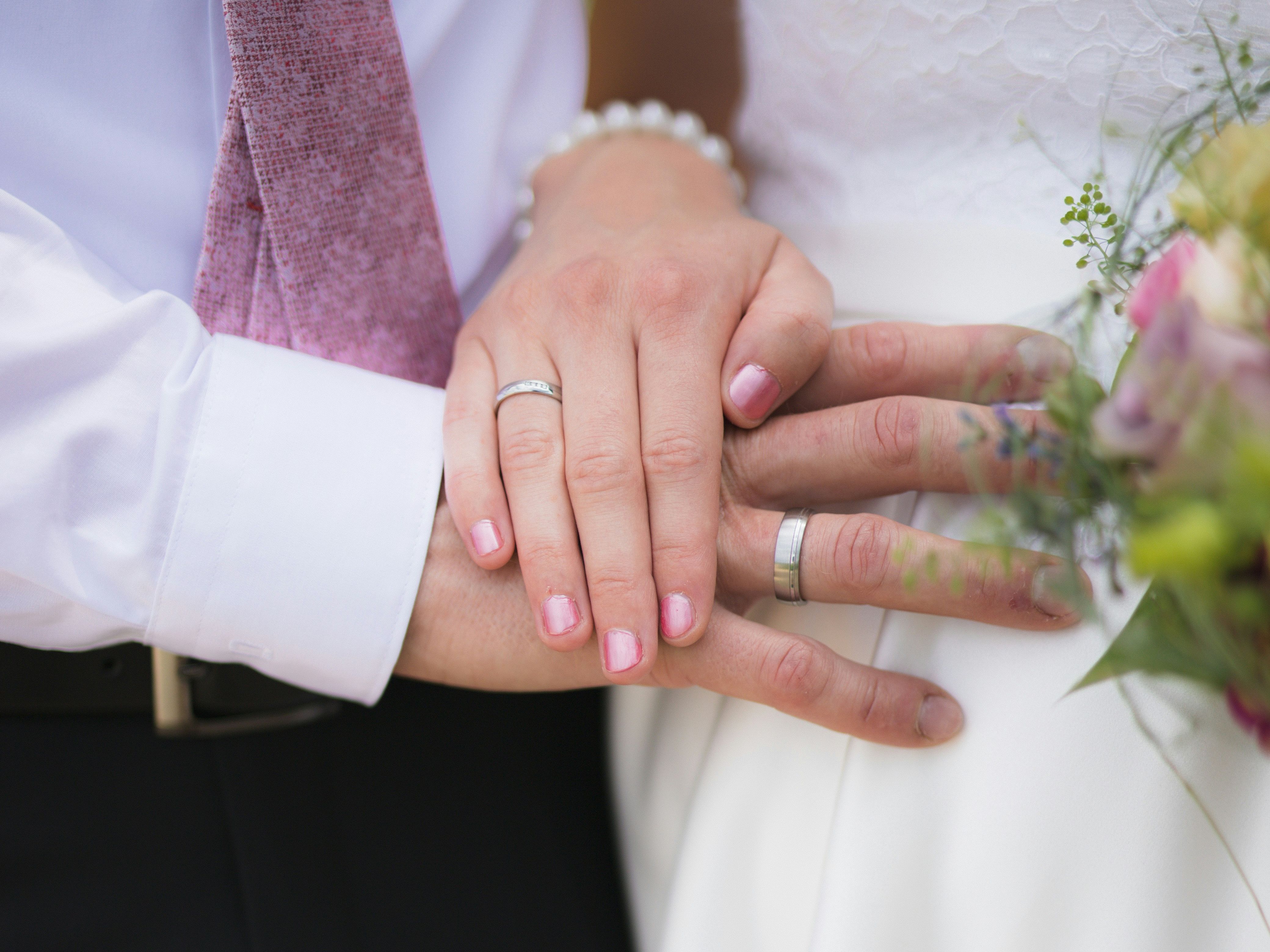 Close-up of a bride and groom's hands with wedding rings