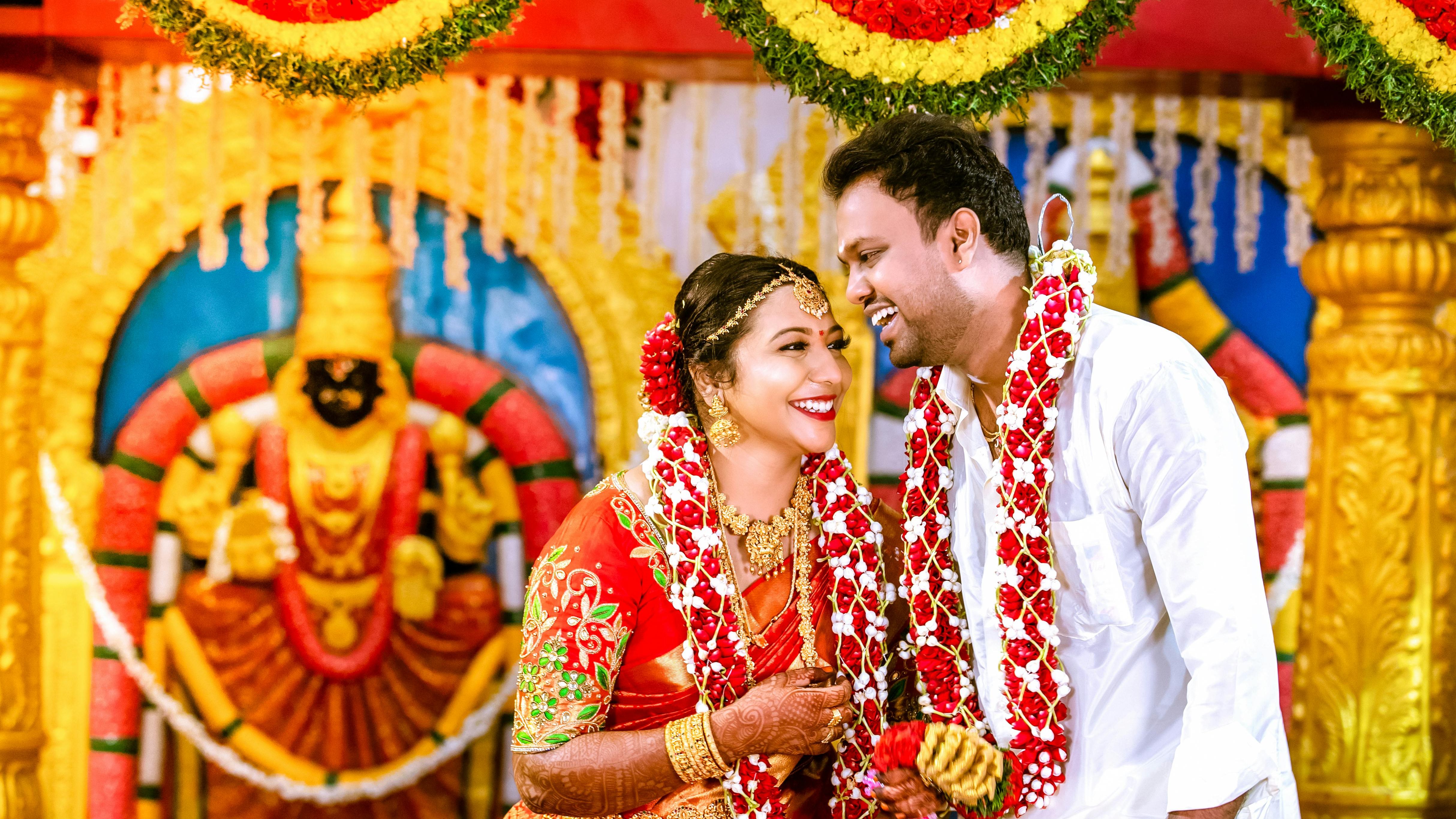 Traditional South Indian wedding couple smiling and adorned with flower garlands