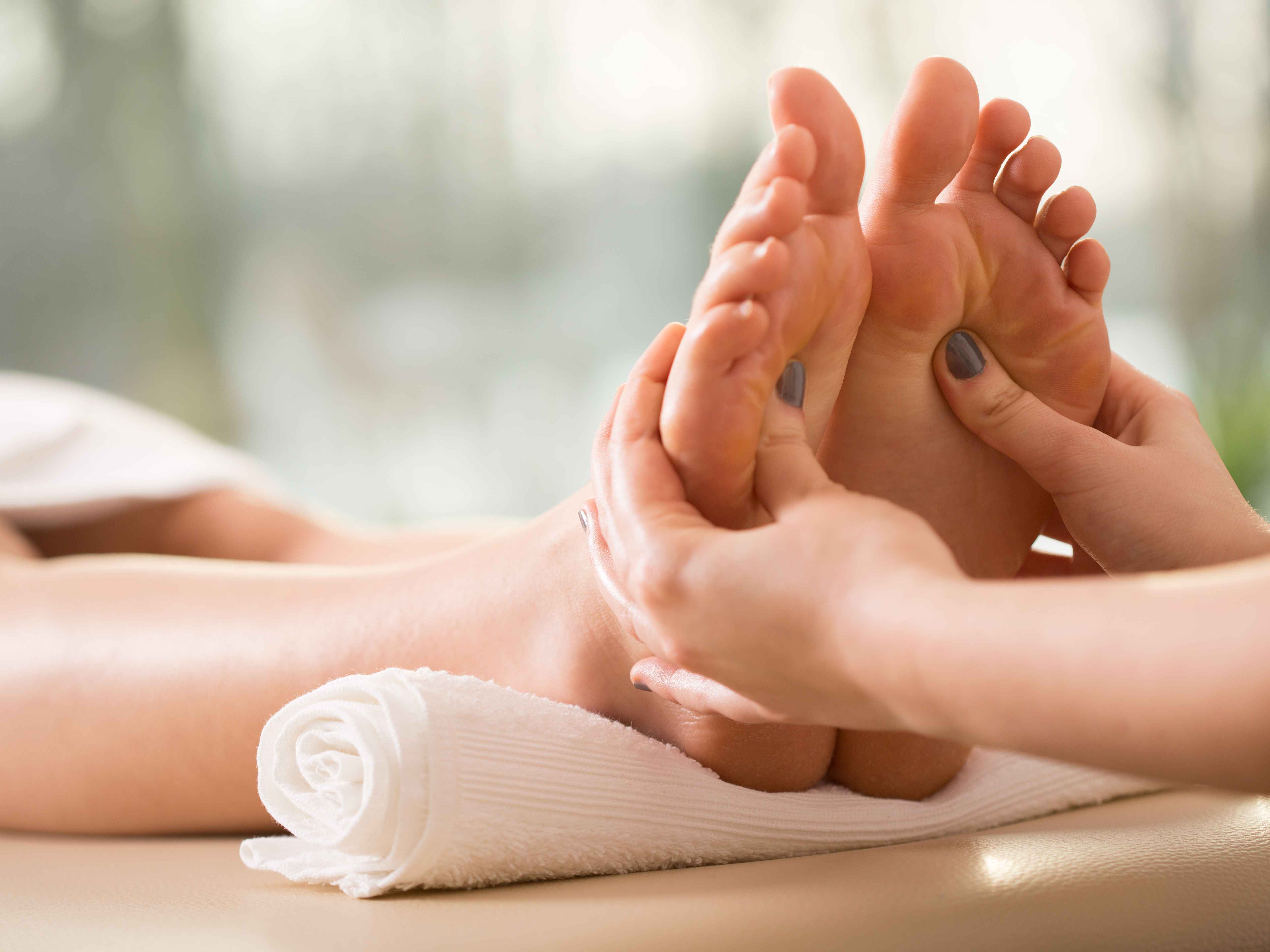 Person receiving a relaxing foot massage in a spa setting