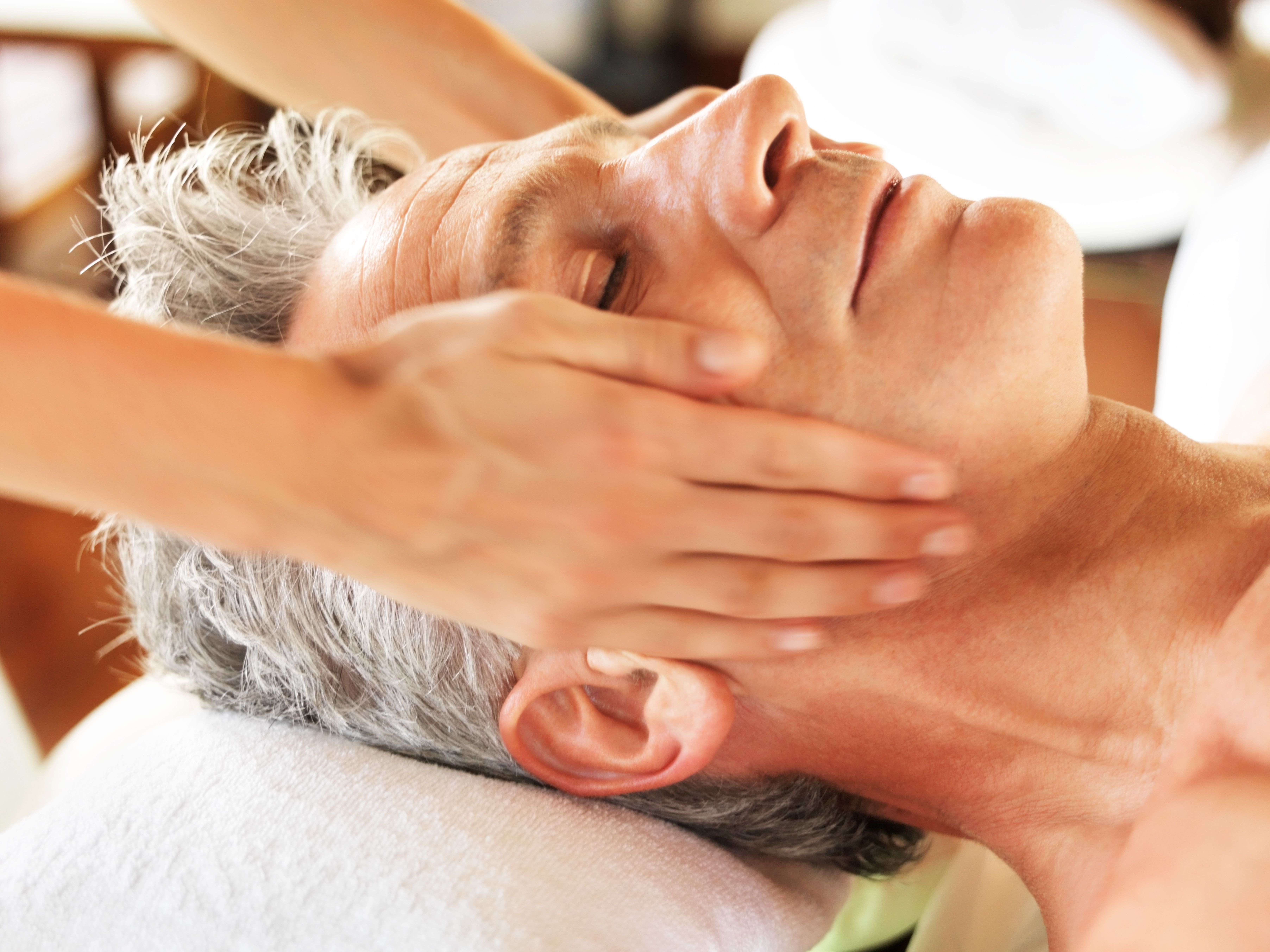 Older man receiving a relaxing facial massage
