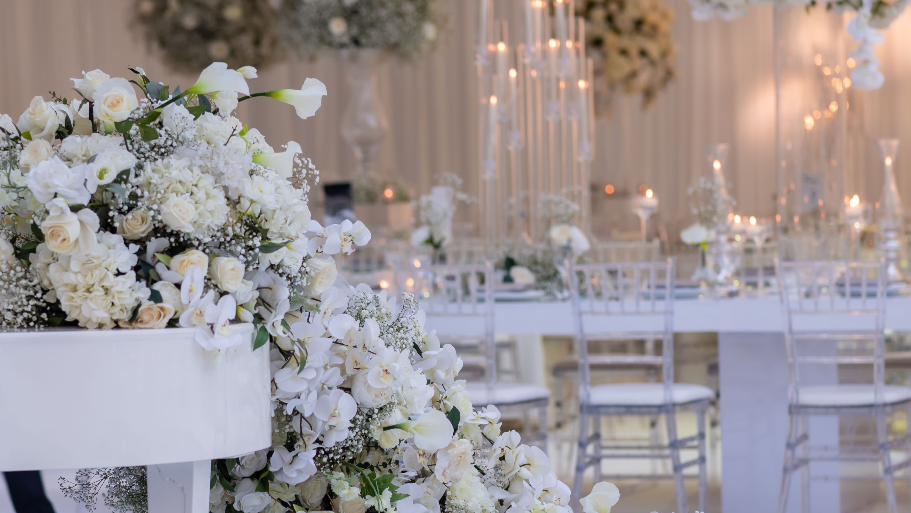 Elegant wedding reception with white floral arrangements and candles