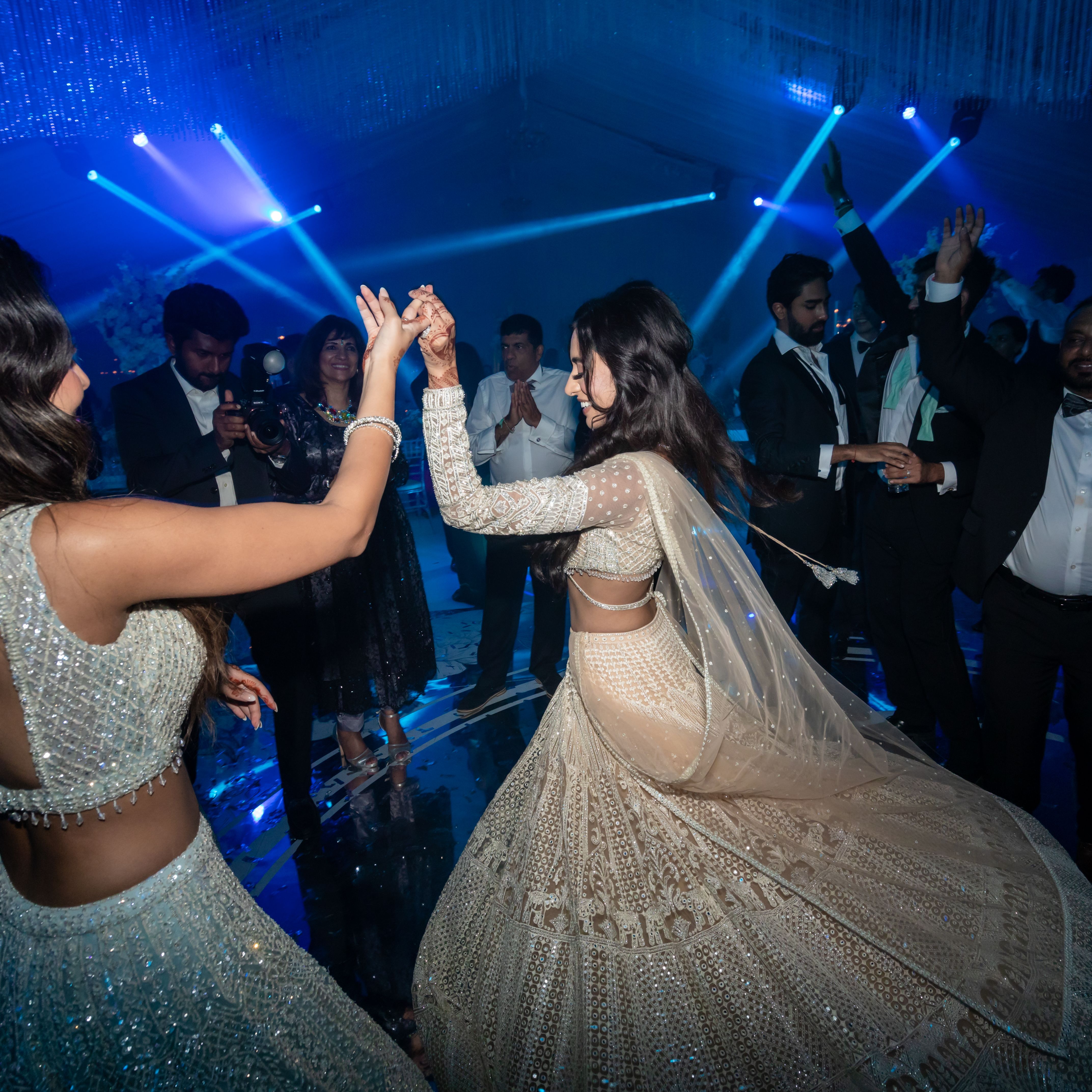Group of people dancing at a formal event with blue lighting