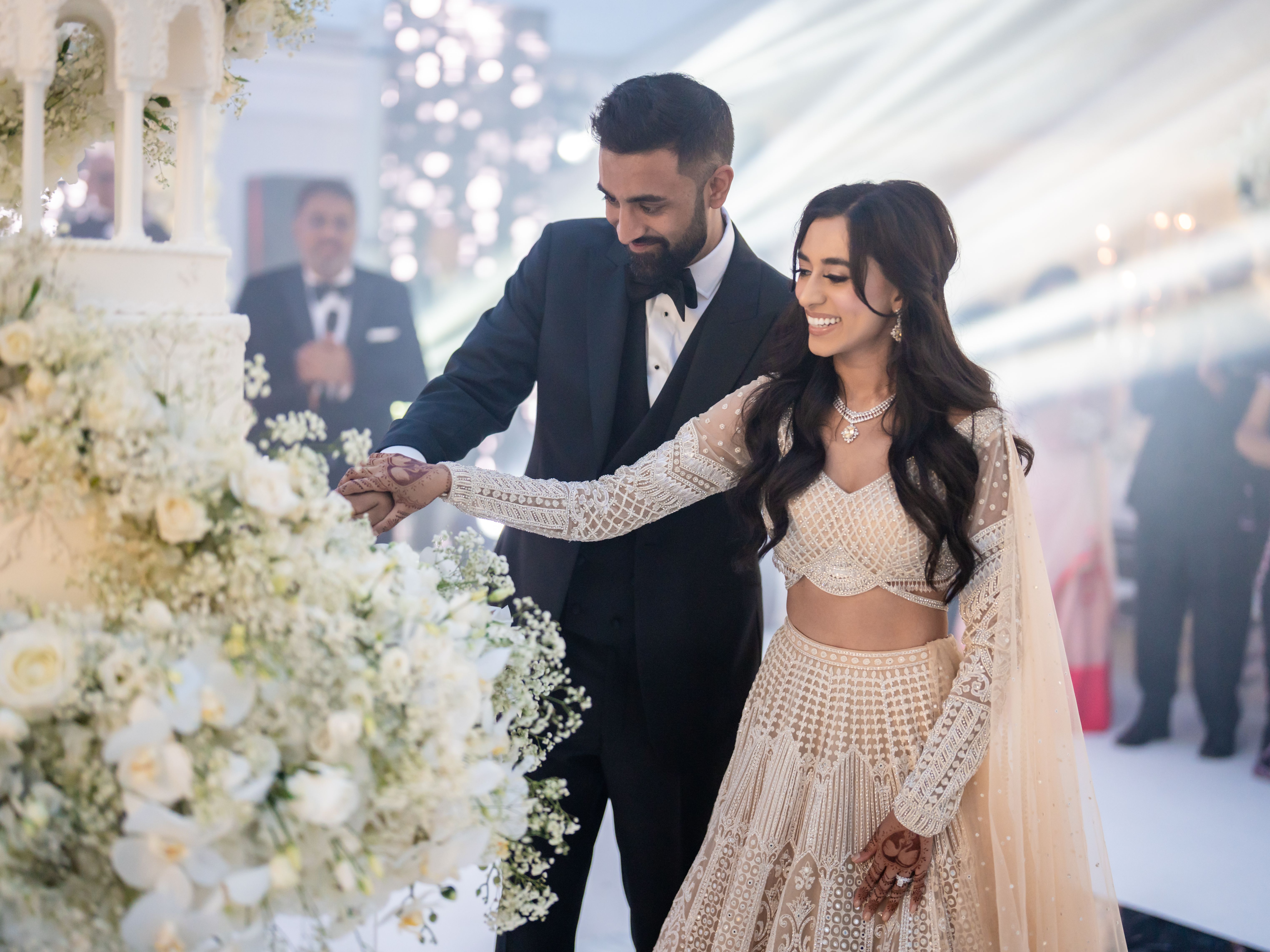 Bride and groom cutting a wedding cake together at their wedding reception.