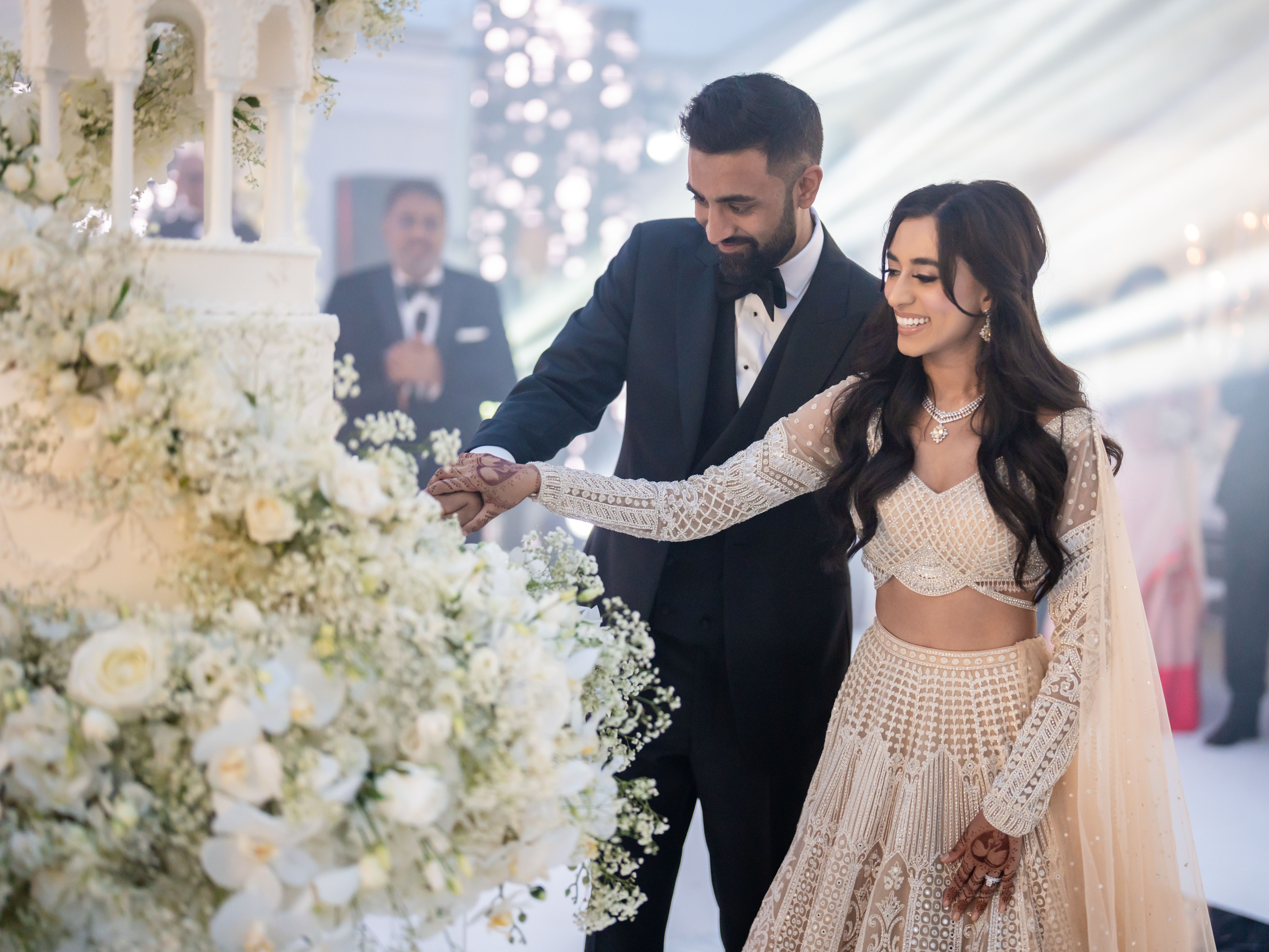 Bride and groom cutting a wedding cake together at their wedding reception.