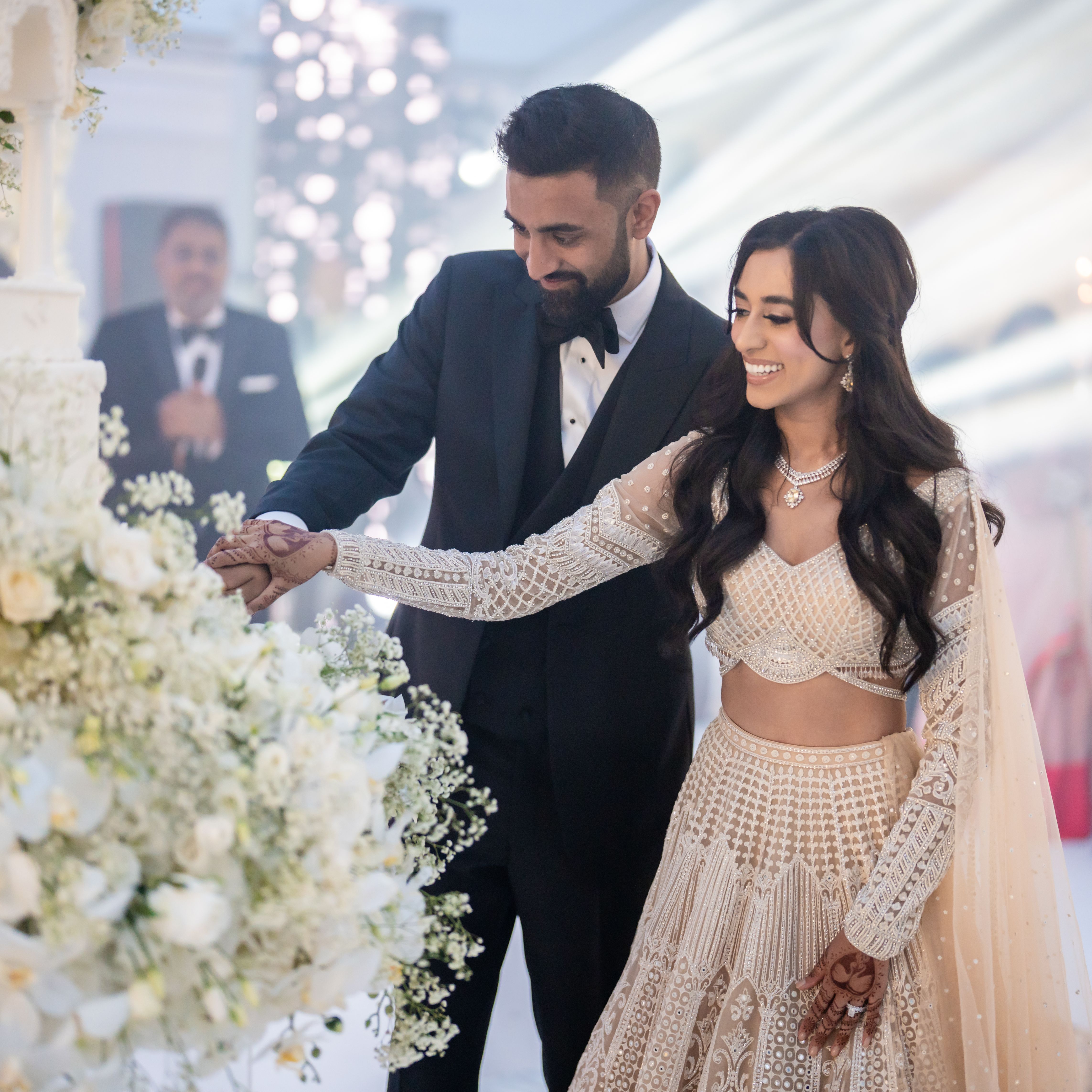 Bride and groom cutting a wedding cake together at their wedding reception.
