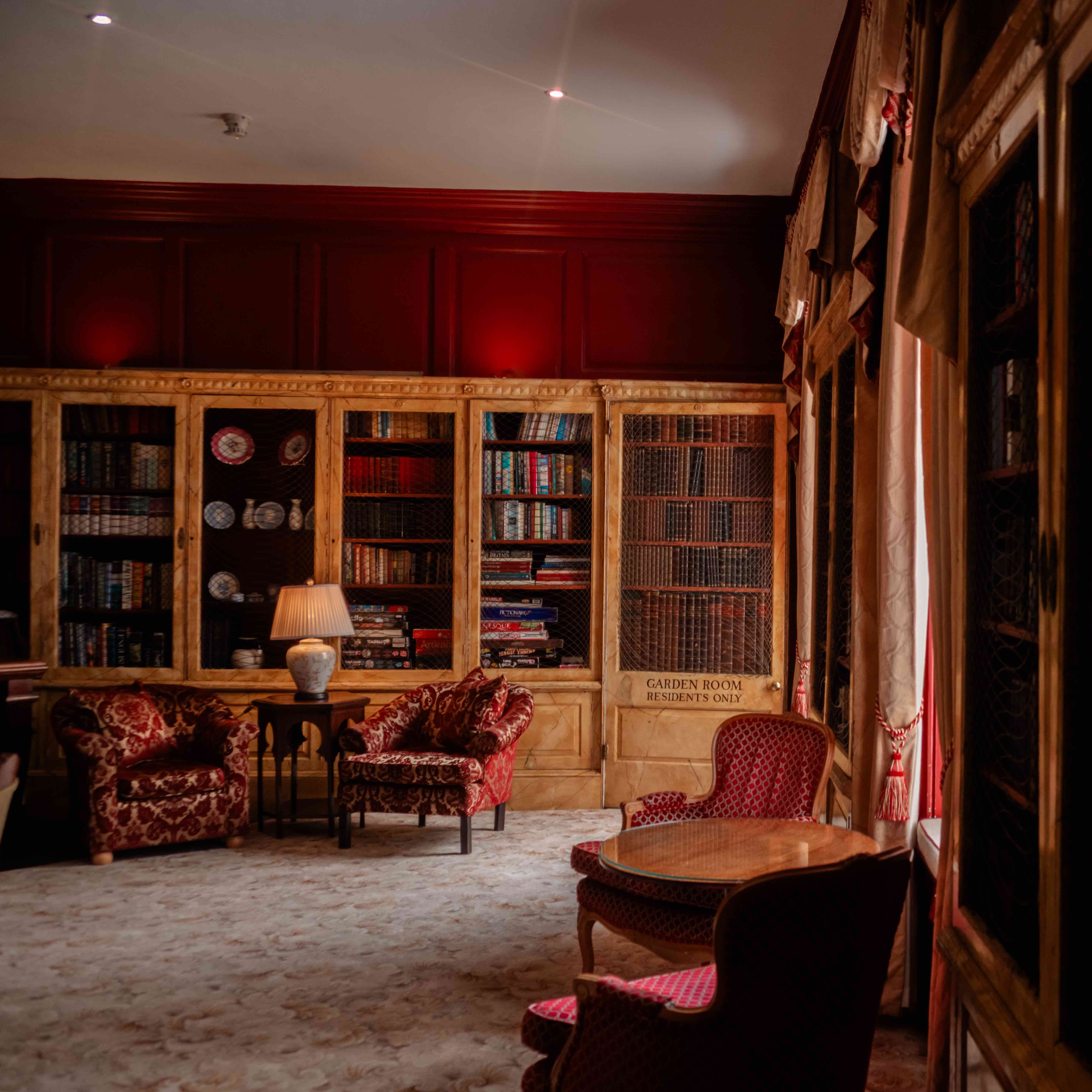 Elegant library room with vintage armchairs, bookshelves, and warm lighting