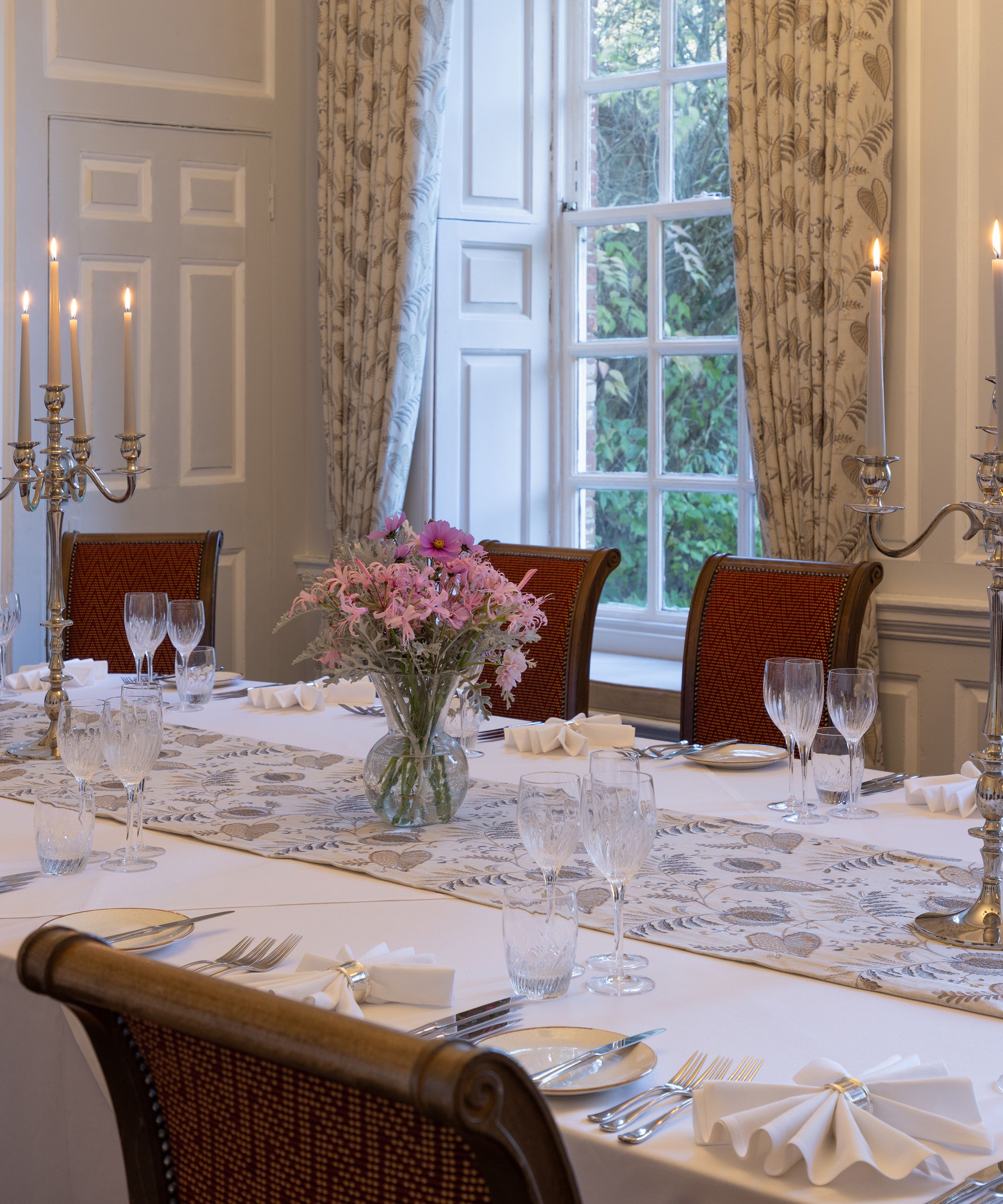 Elegant dining room with set table, candelabra, and floral centerpiece