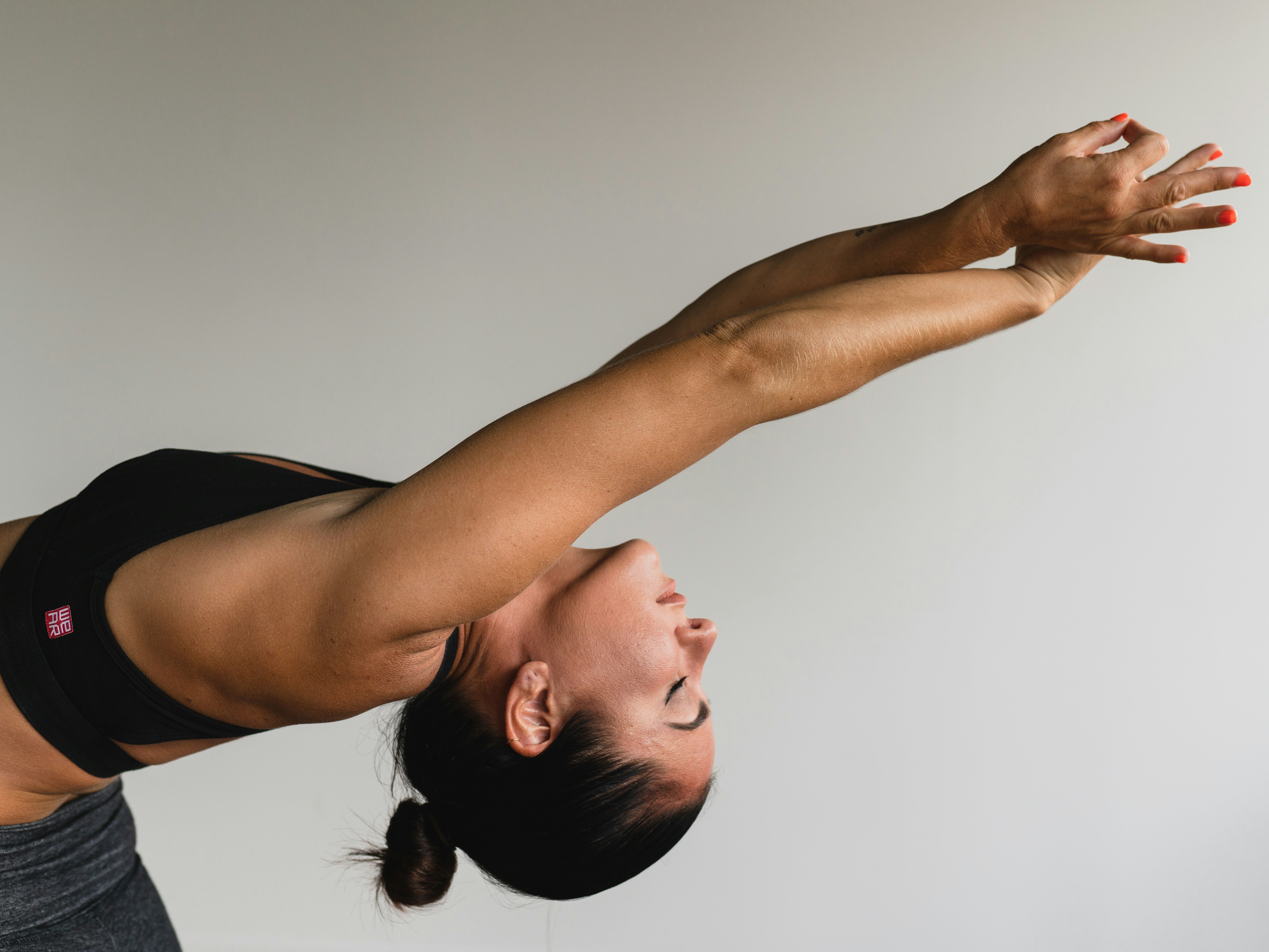 Woman in a yoga pose stretching arms backwards