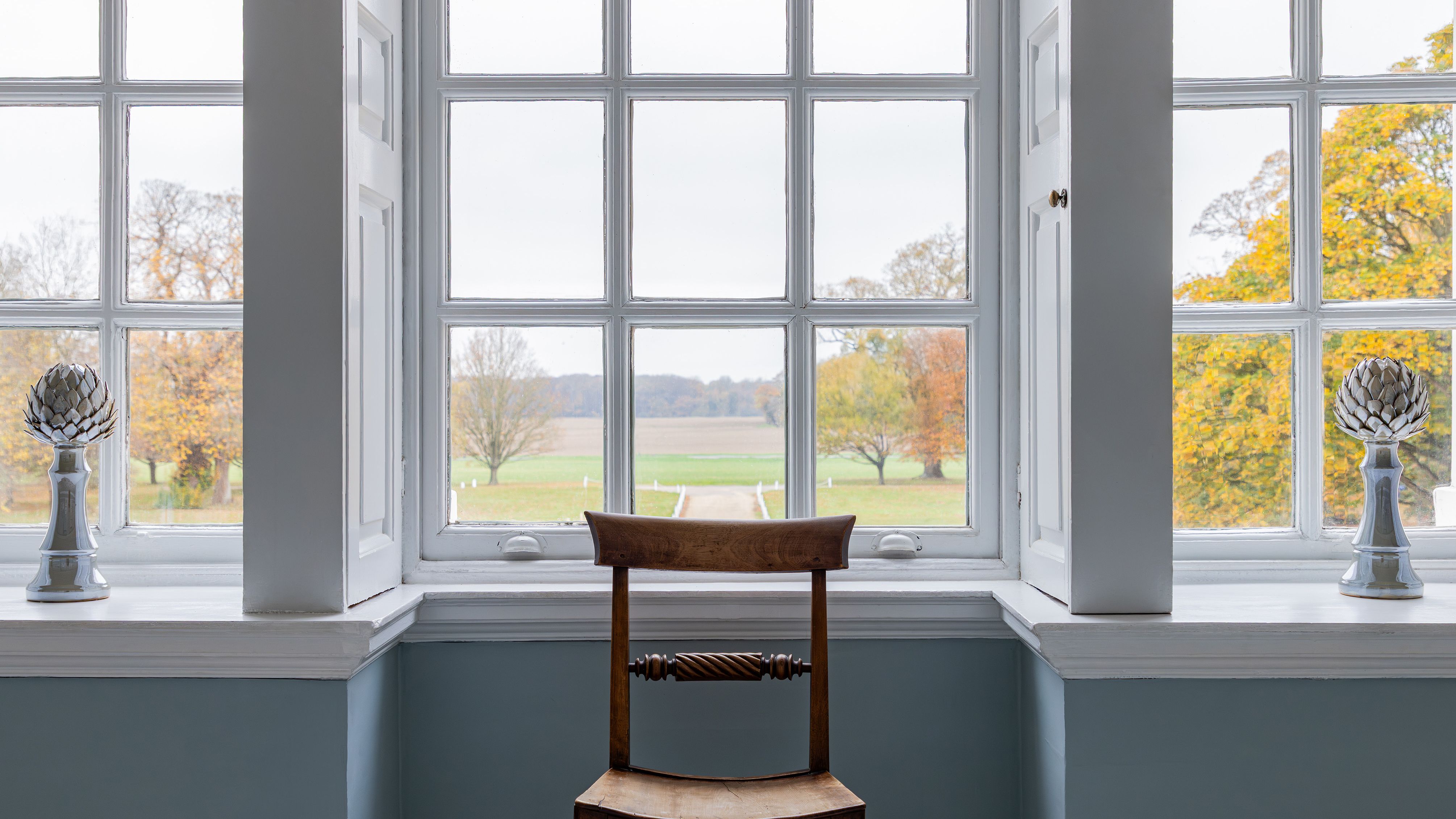 Wooden chair in front of a large window with a scenic outdoor view