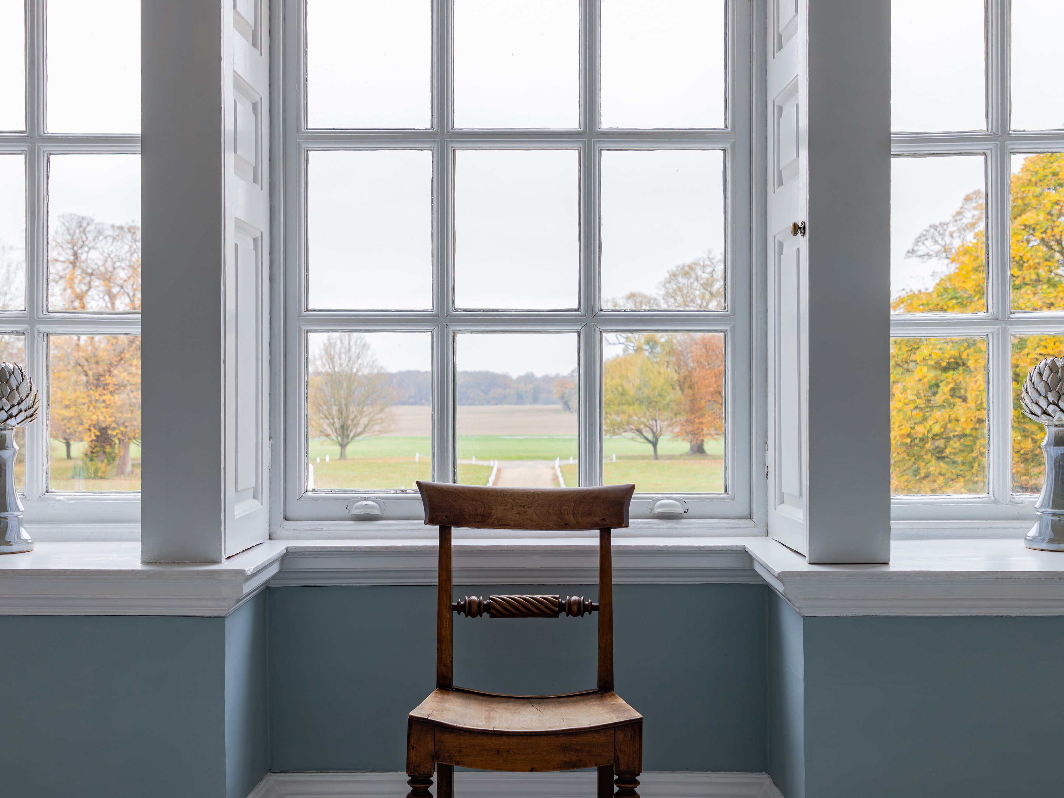Wooden chair in front of a large window with a scenic outdoor view