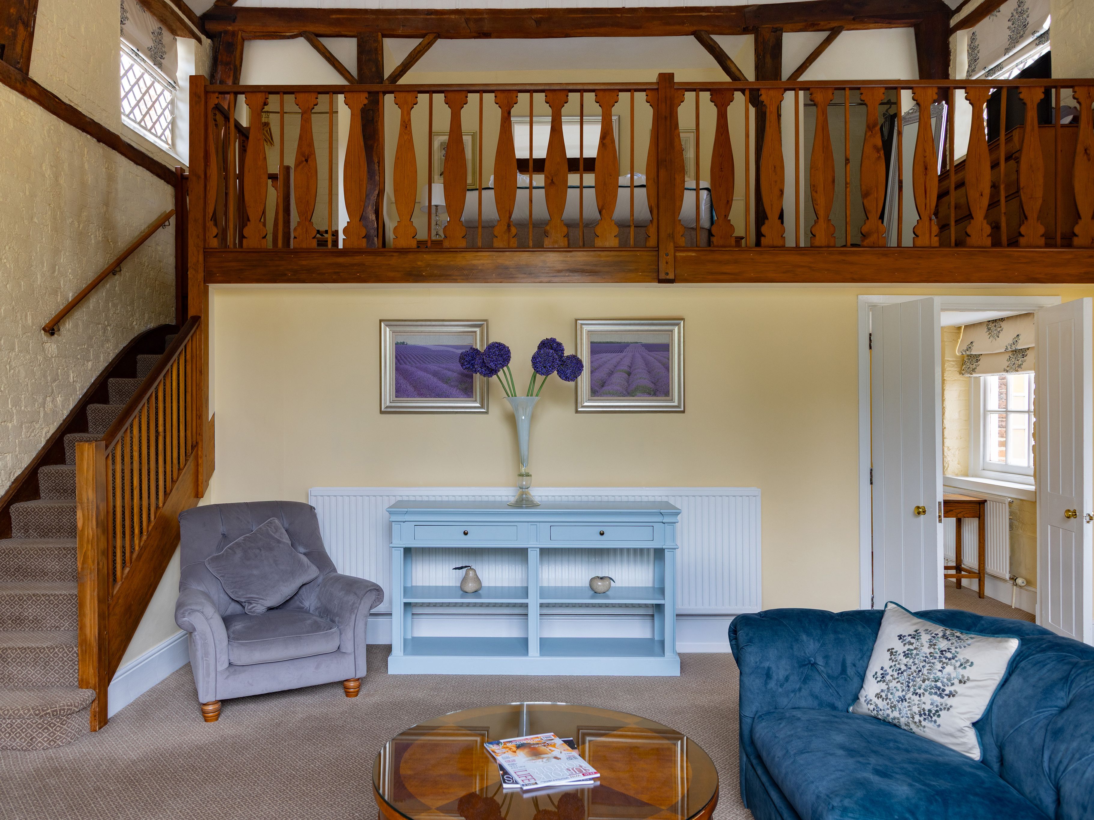 Cozy living room with loft bedroom, staircase, and comfortable furniture