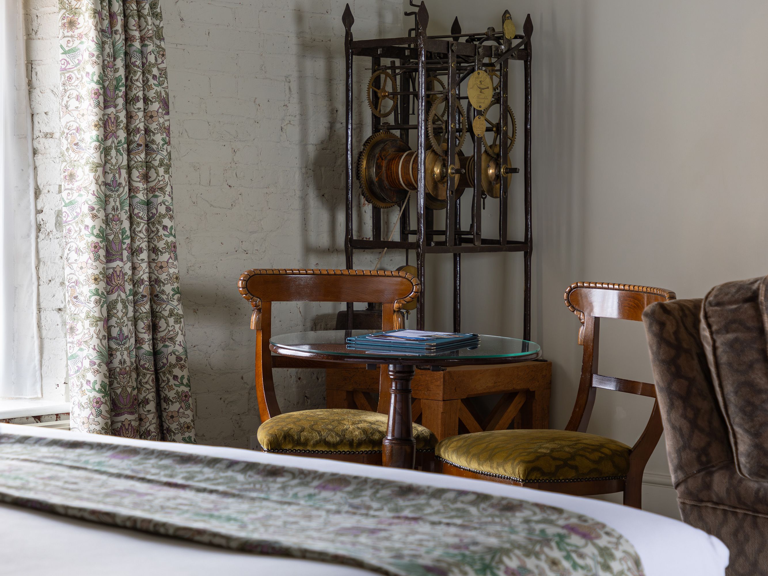 Cozy bedroom corner with vintage chairs, small table, and floral decor
