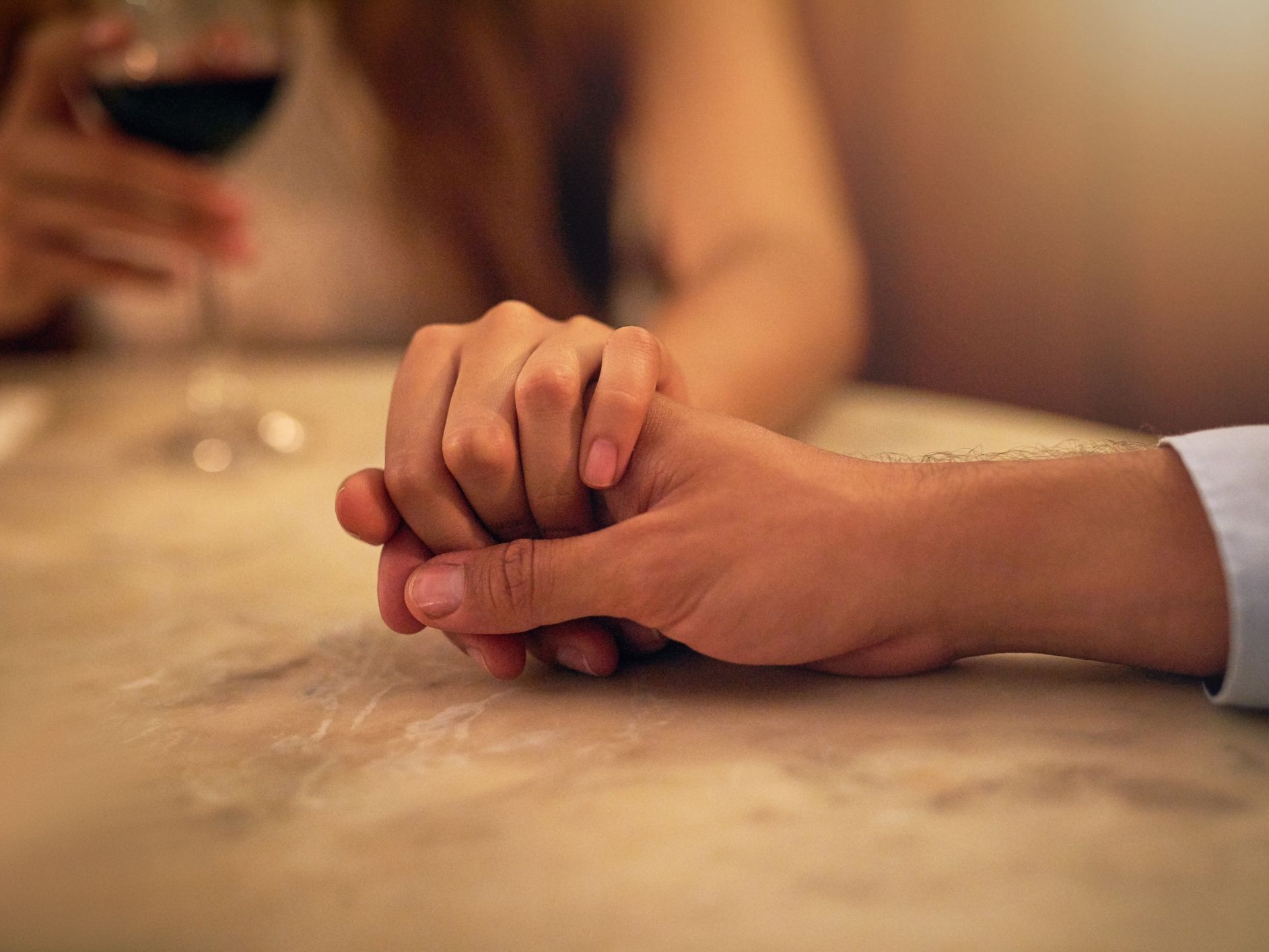 Couple holding hands across a table at a restaurant