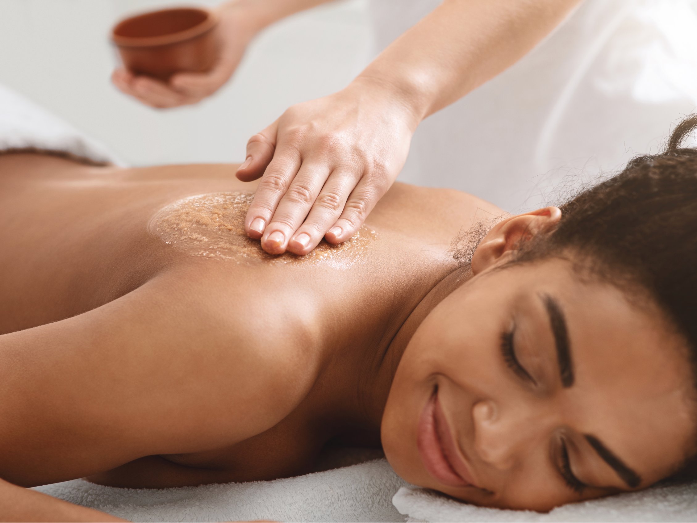 Woman receiving a relaxing back scrub massage at a spa