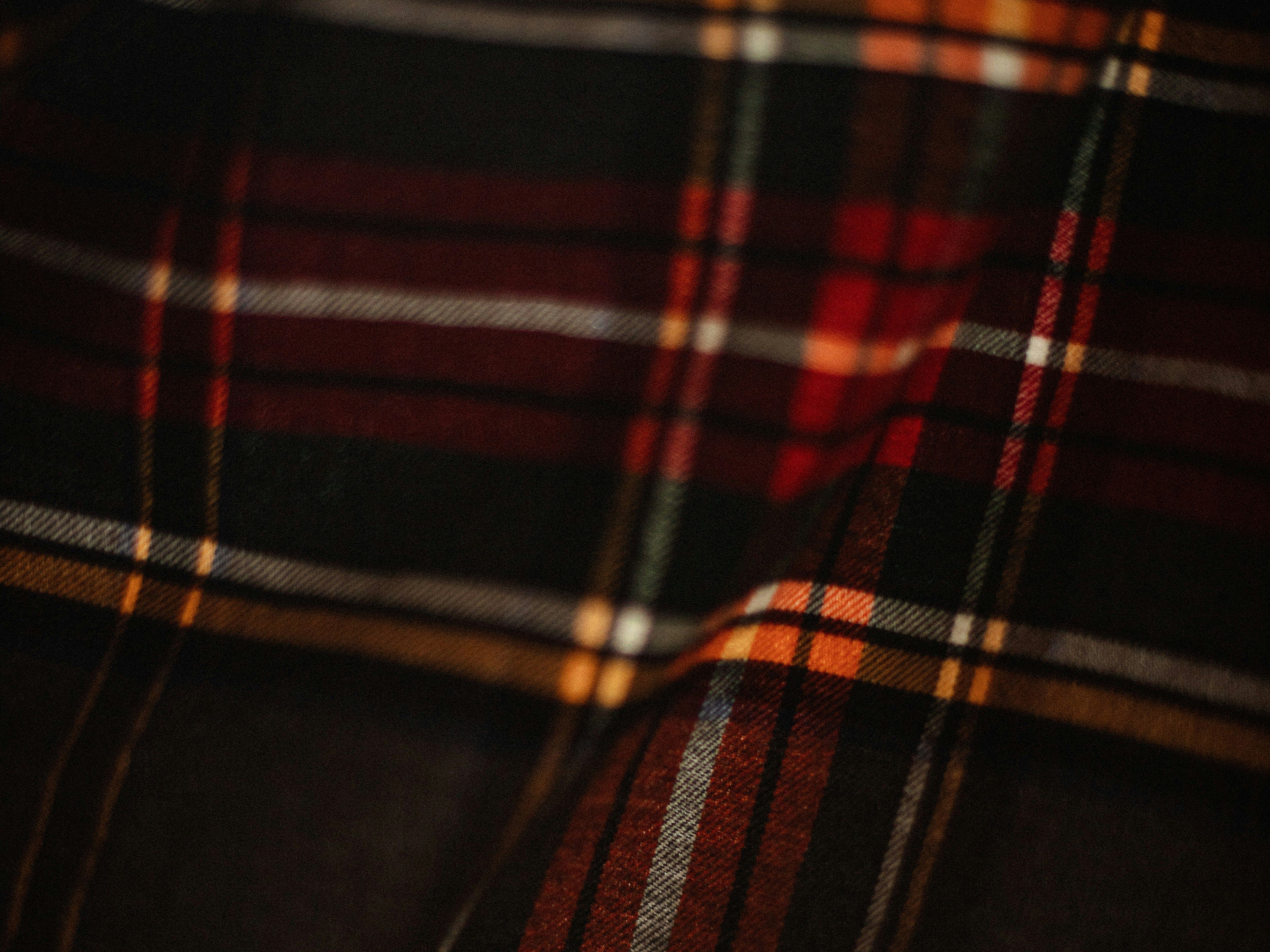 Close-up of a dark plaid fabric with red, orange, and yellow lines