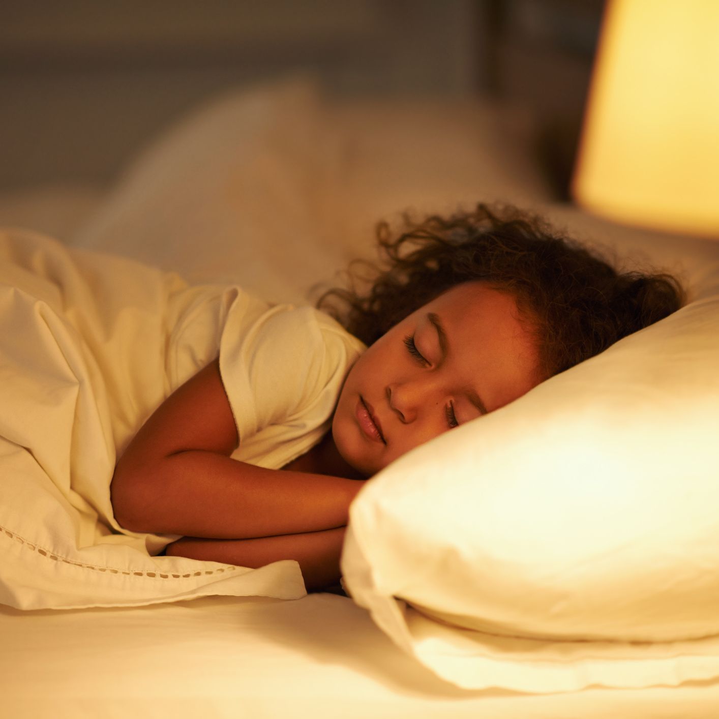 Child sleeping peacefully in bed with soft lighting