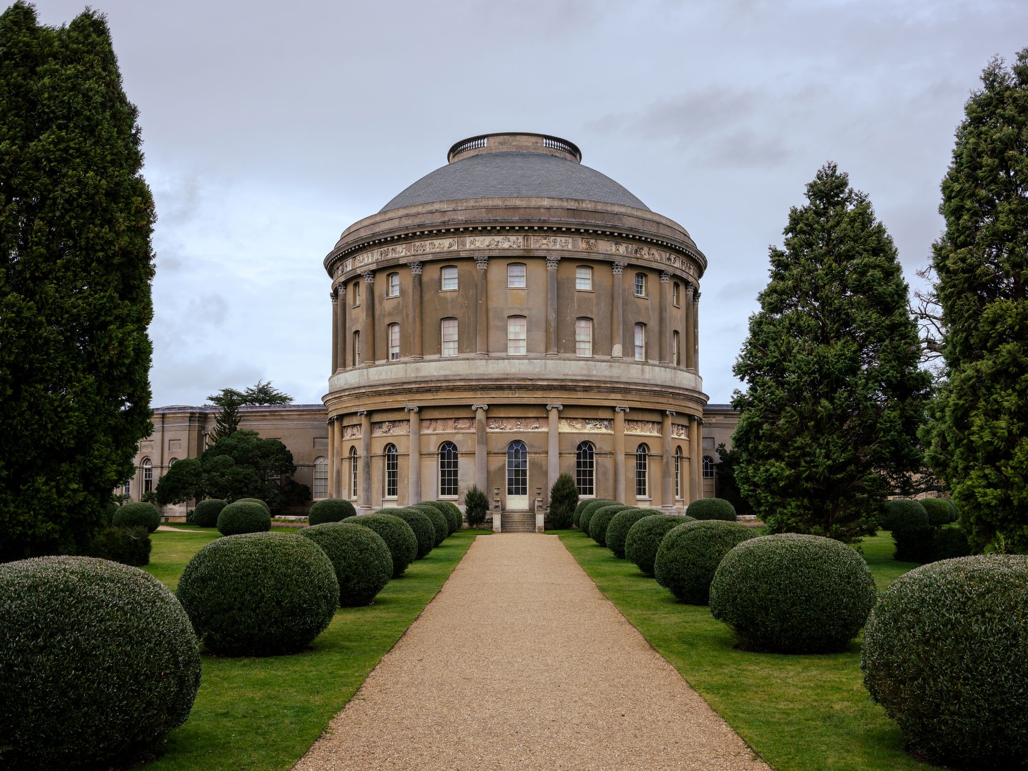 Neoclassical rotunda building with landscaped gardens and neatly trimmed bushes